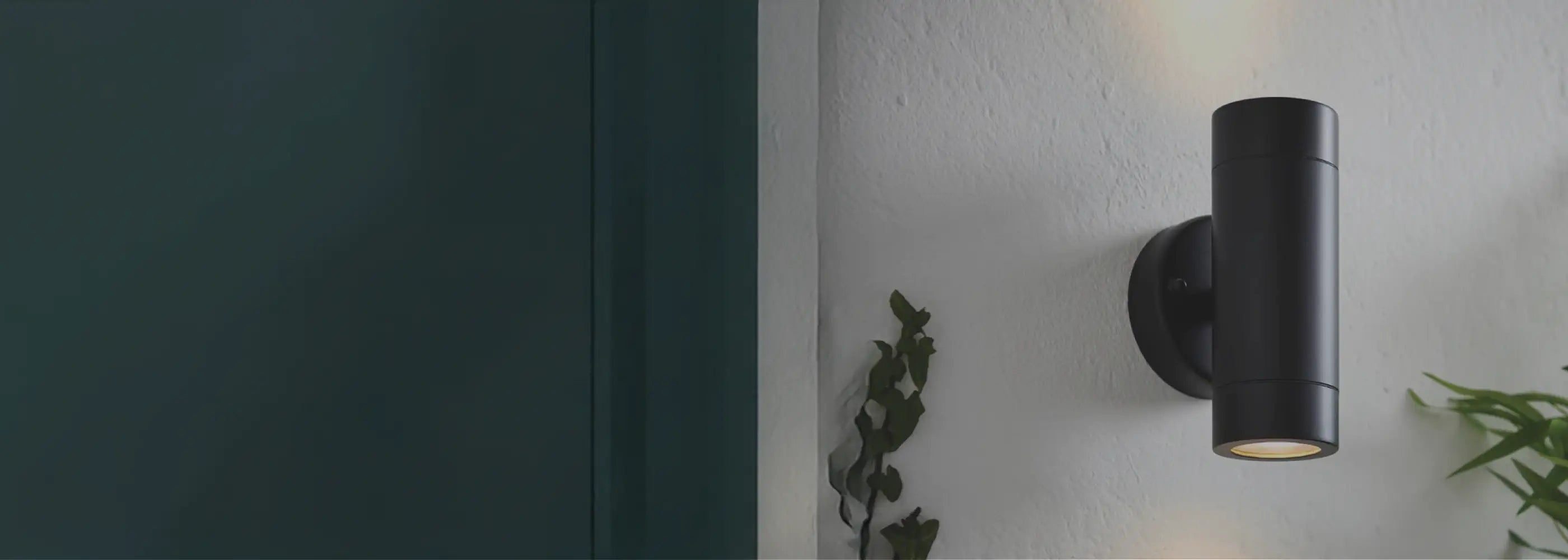 Black outdoor wall light fixture on a white wall