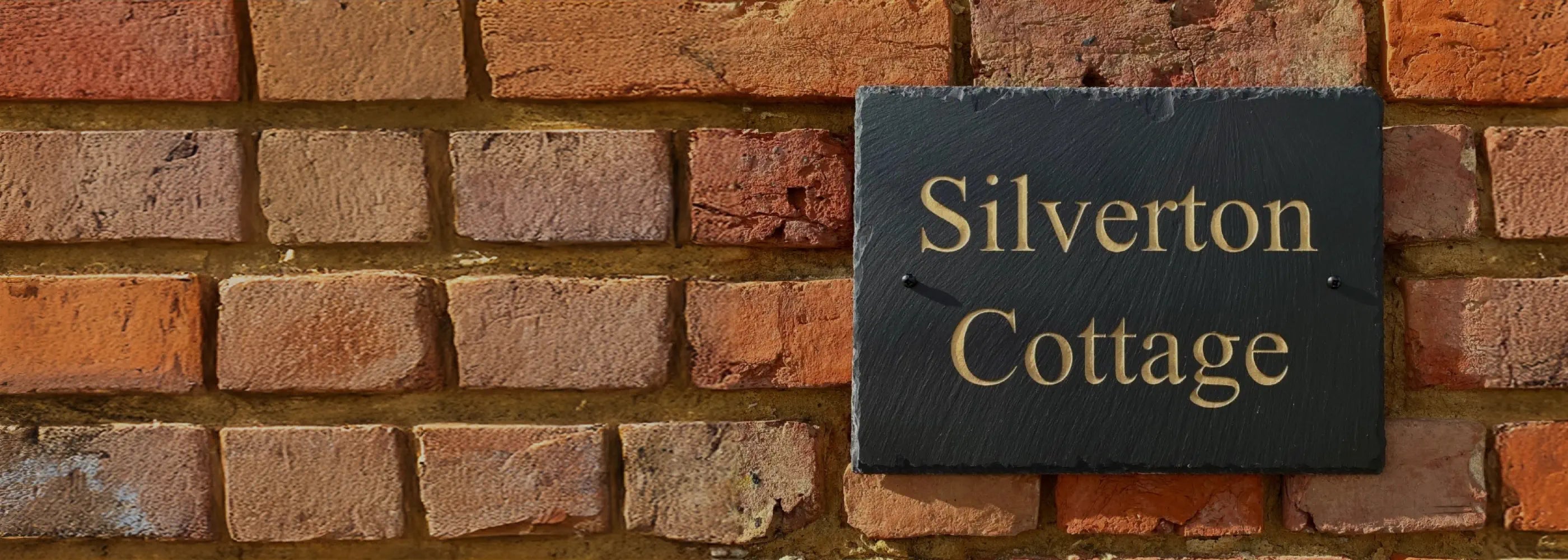 Brick wall with a sign reading 'Silverton Cottage'