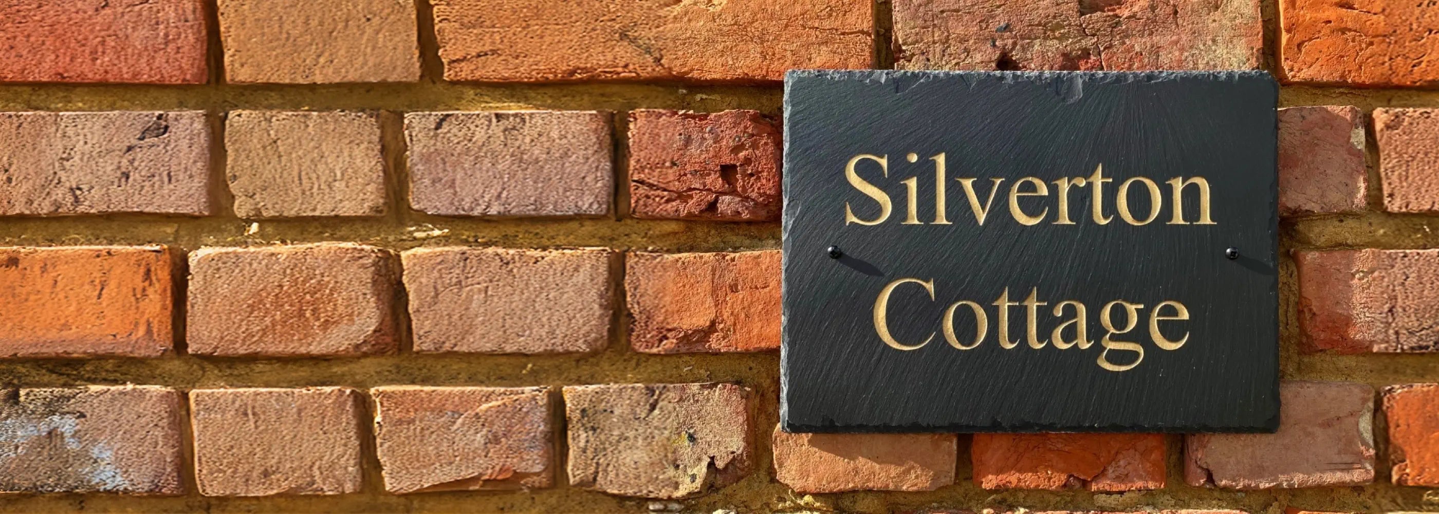 Brick wall with a sign reading 'Silverton Cottage'