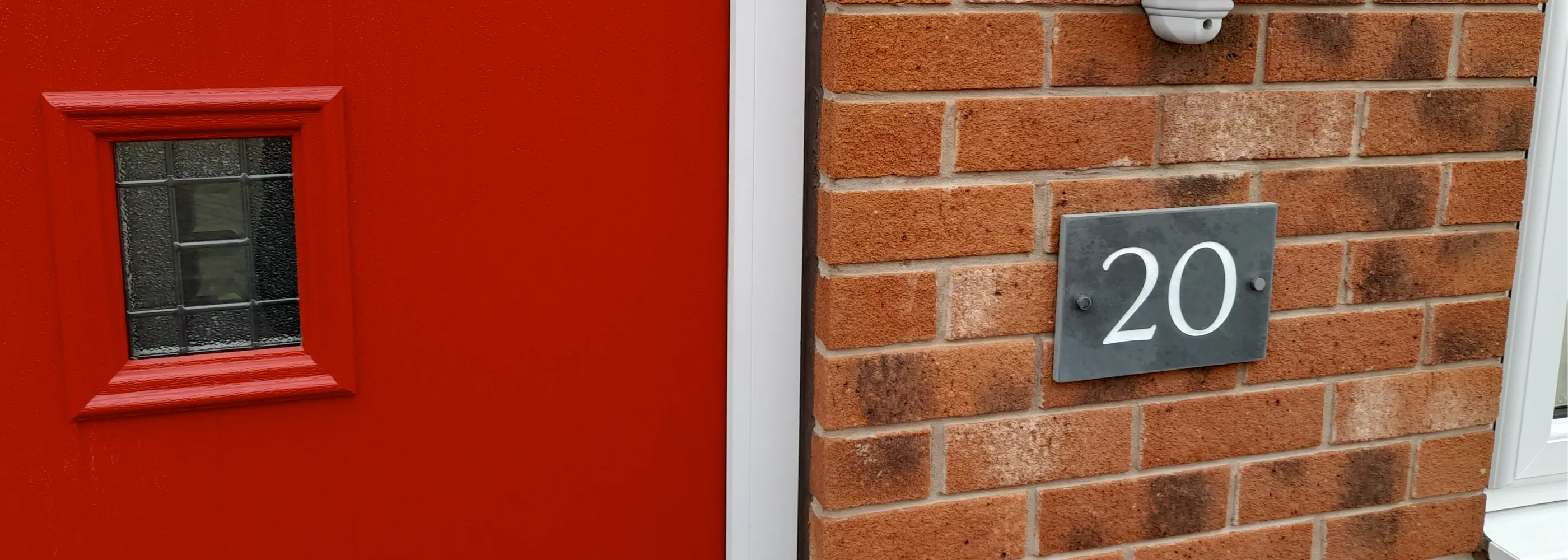 House number sign with '55 Cattle Dyke' on a brick wall