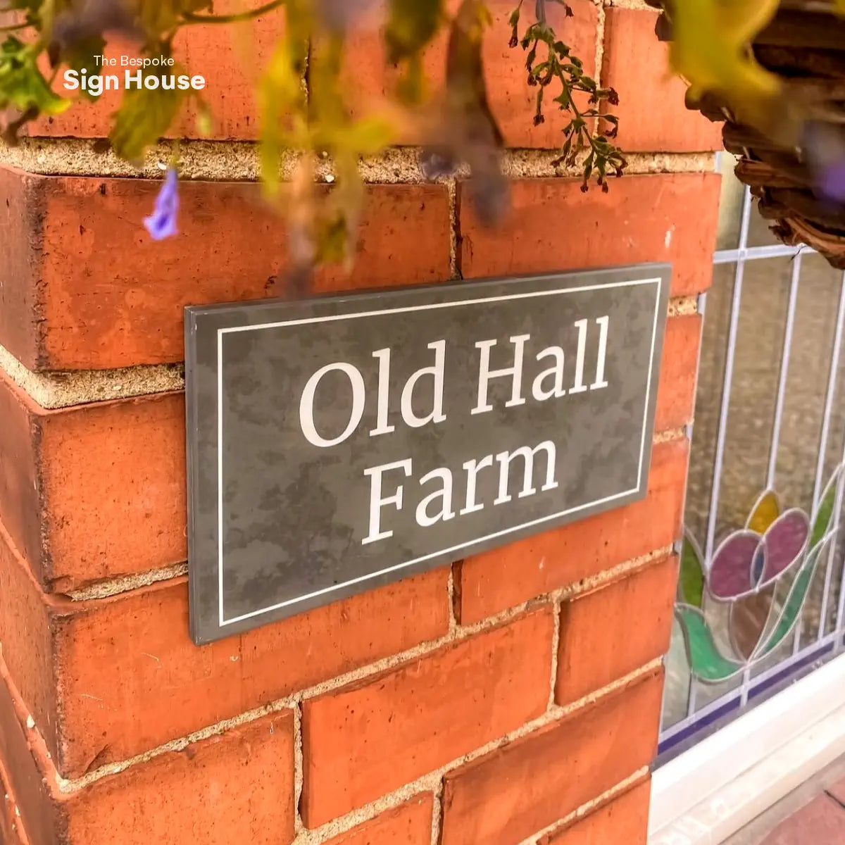 grey slate wall sign with a line border and the house name engraved in white