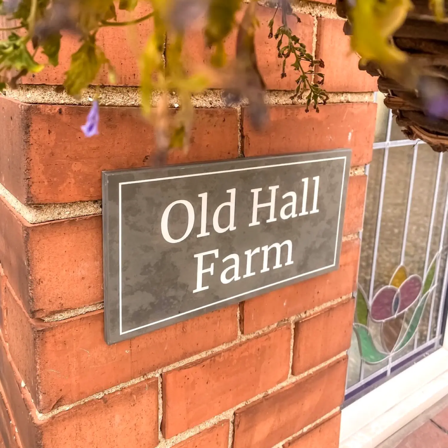 grey slate wall sign with a line border and the house name engraved in white