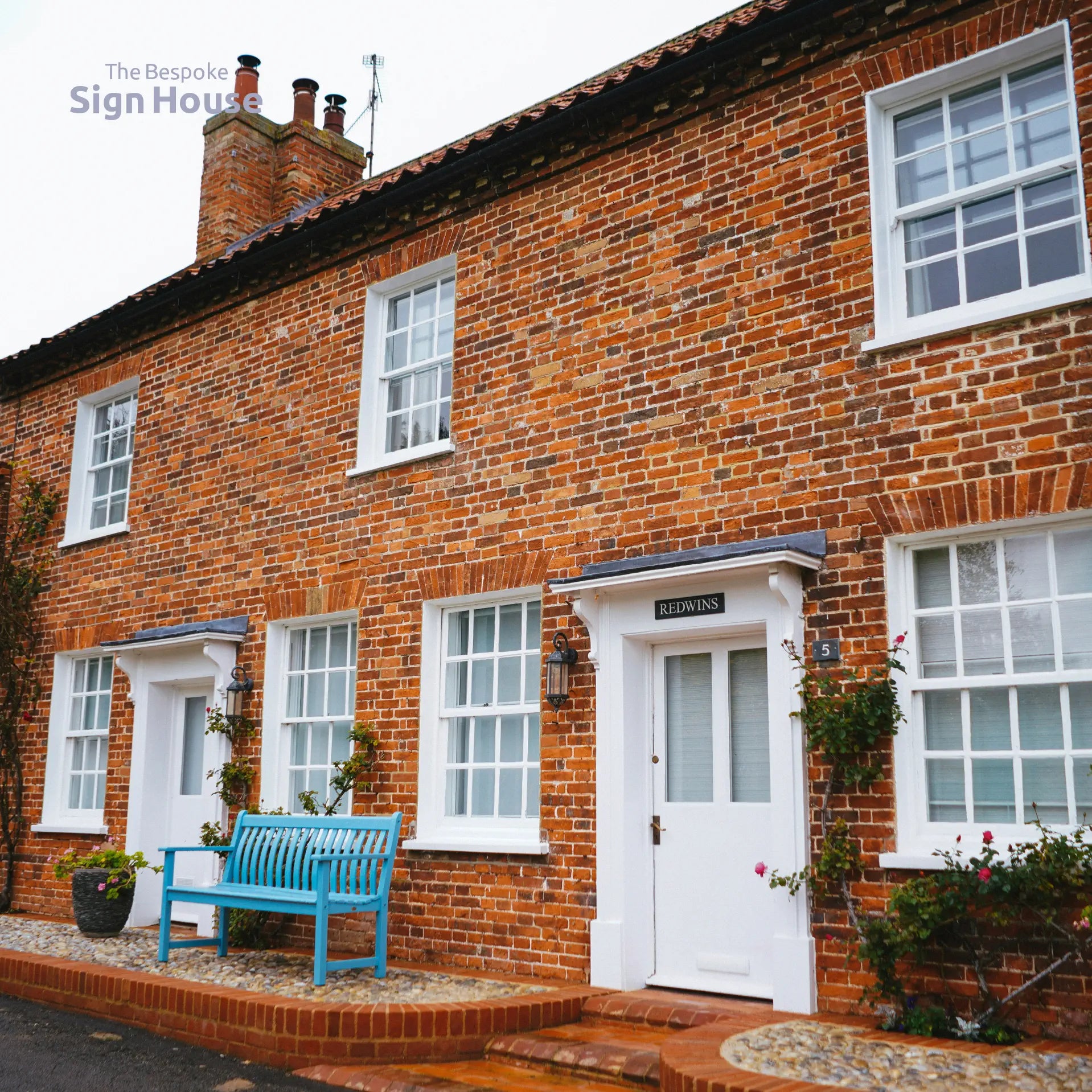 Brick house with a blue bench in front