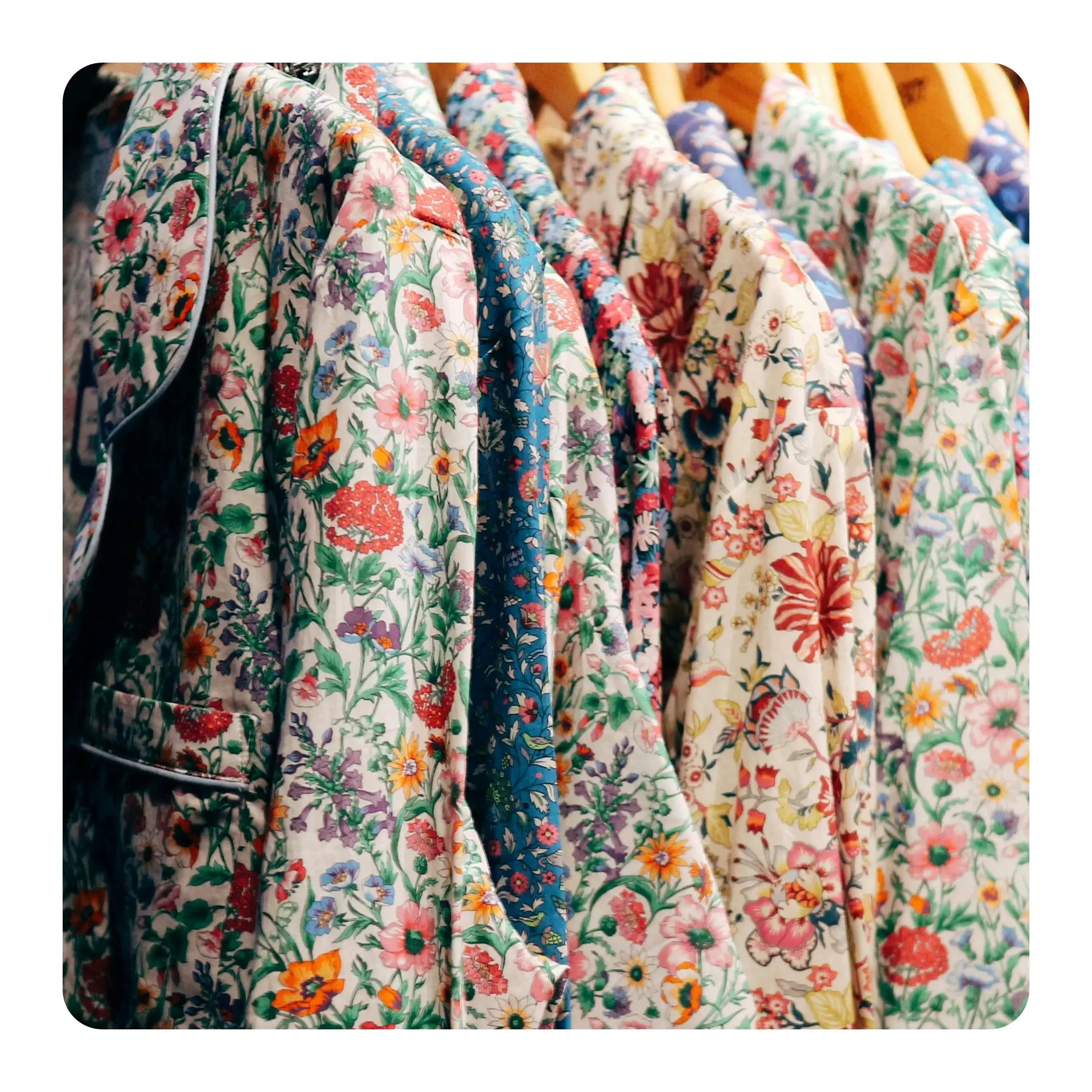 a selection of womens floral jackets hanging in a wardrobe