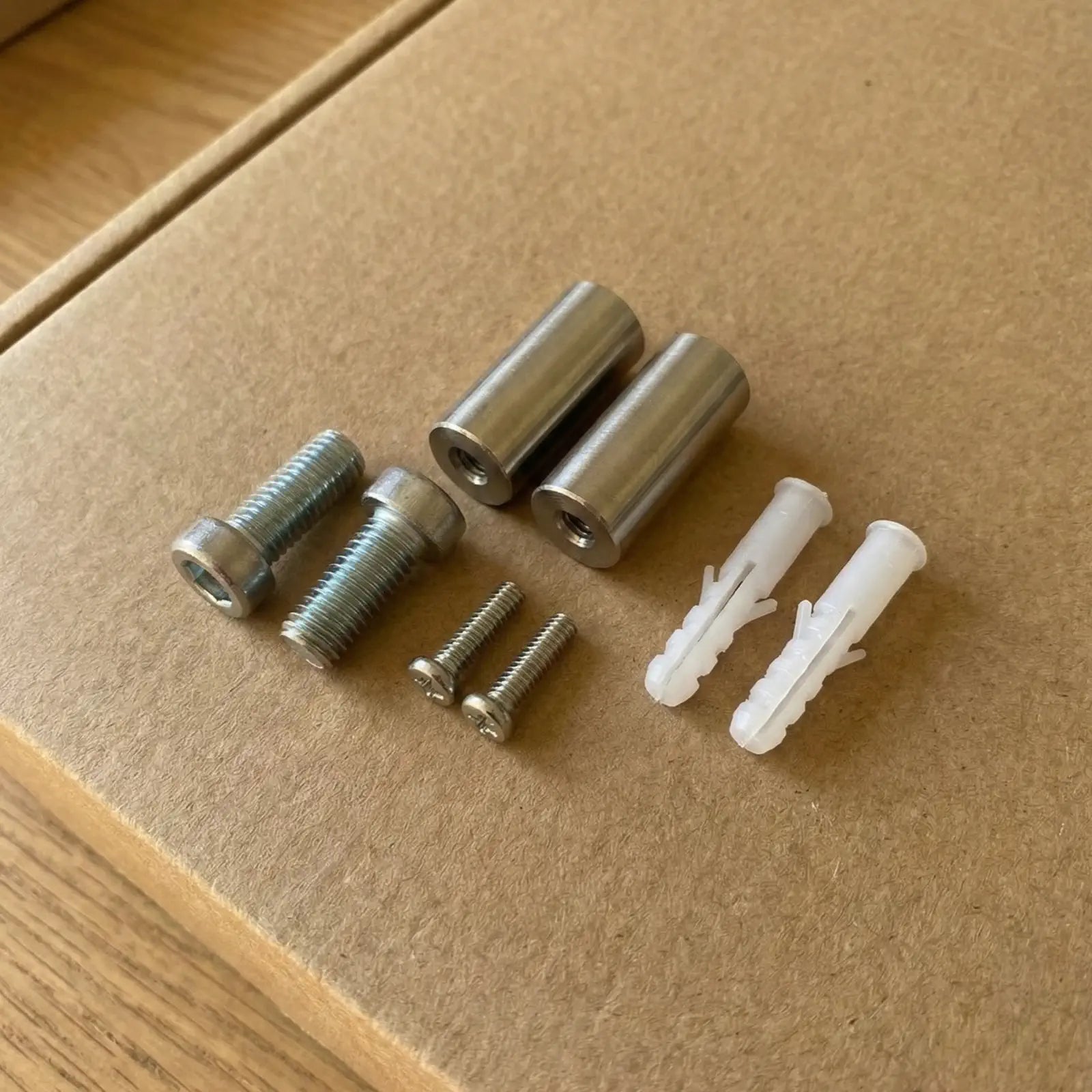 Collection of screws, screw caps, and a tube of adhesive on a white background