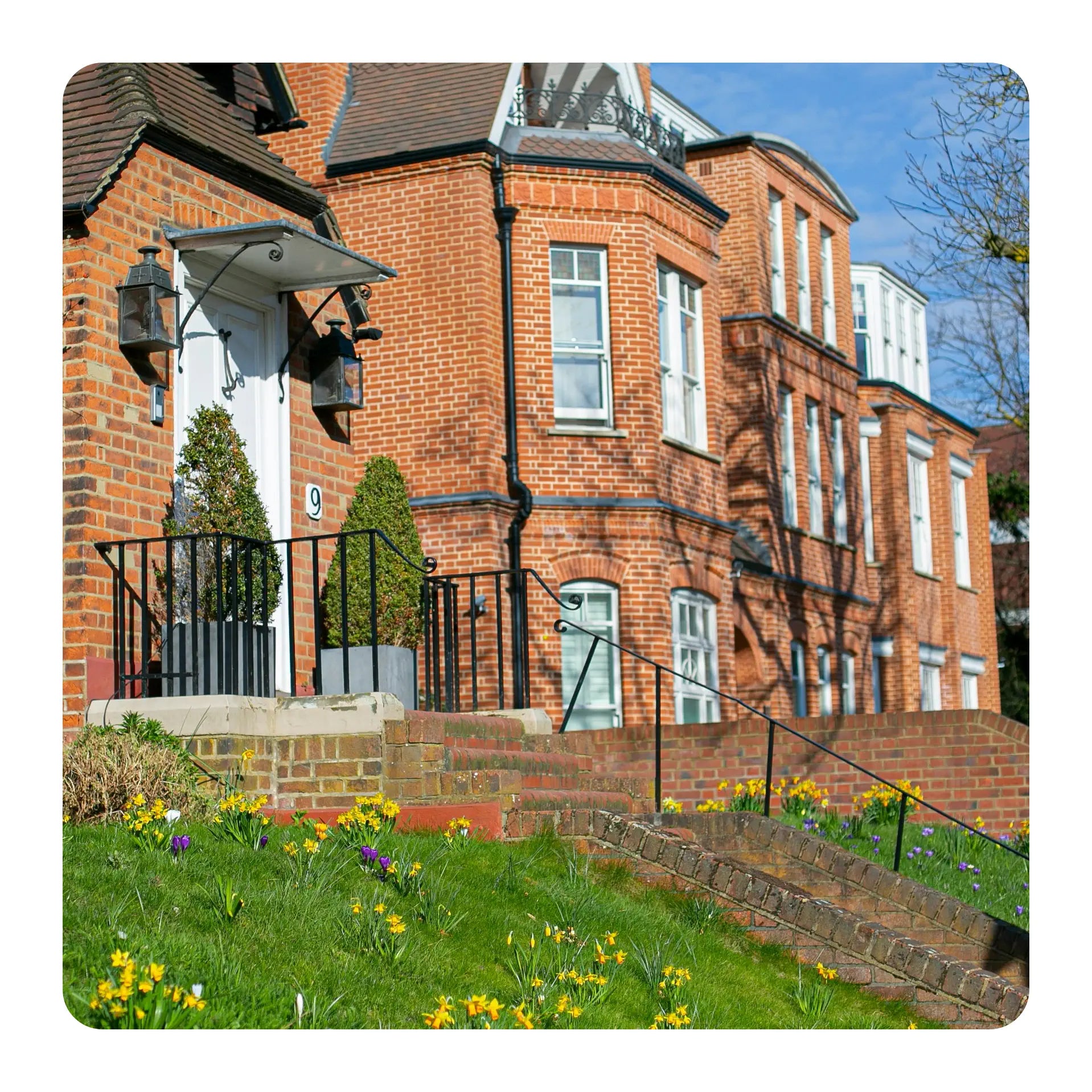 Brick building with a garden and flowers in front