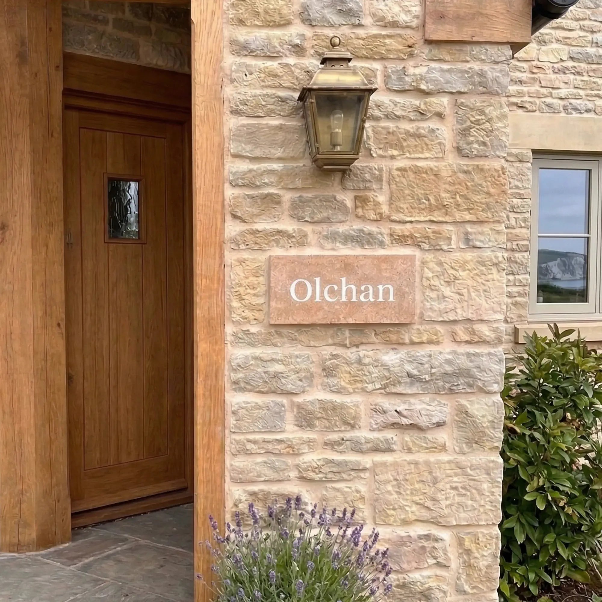 Stone building exterior with a wooden door and 'Olchan' sign.