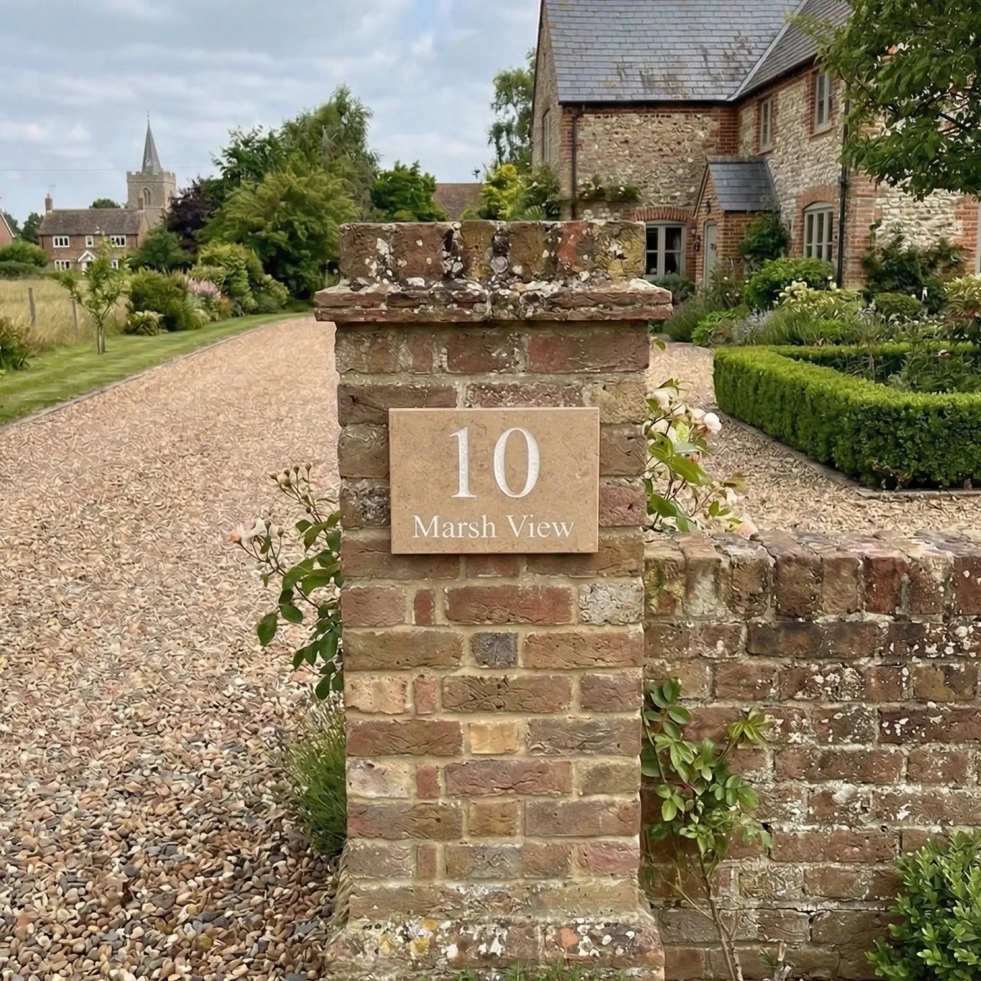 a limestone sign reading 10 marsh view on a brick driveway pillar near Ely