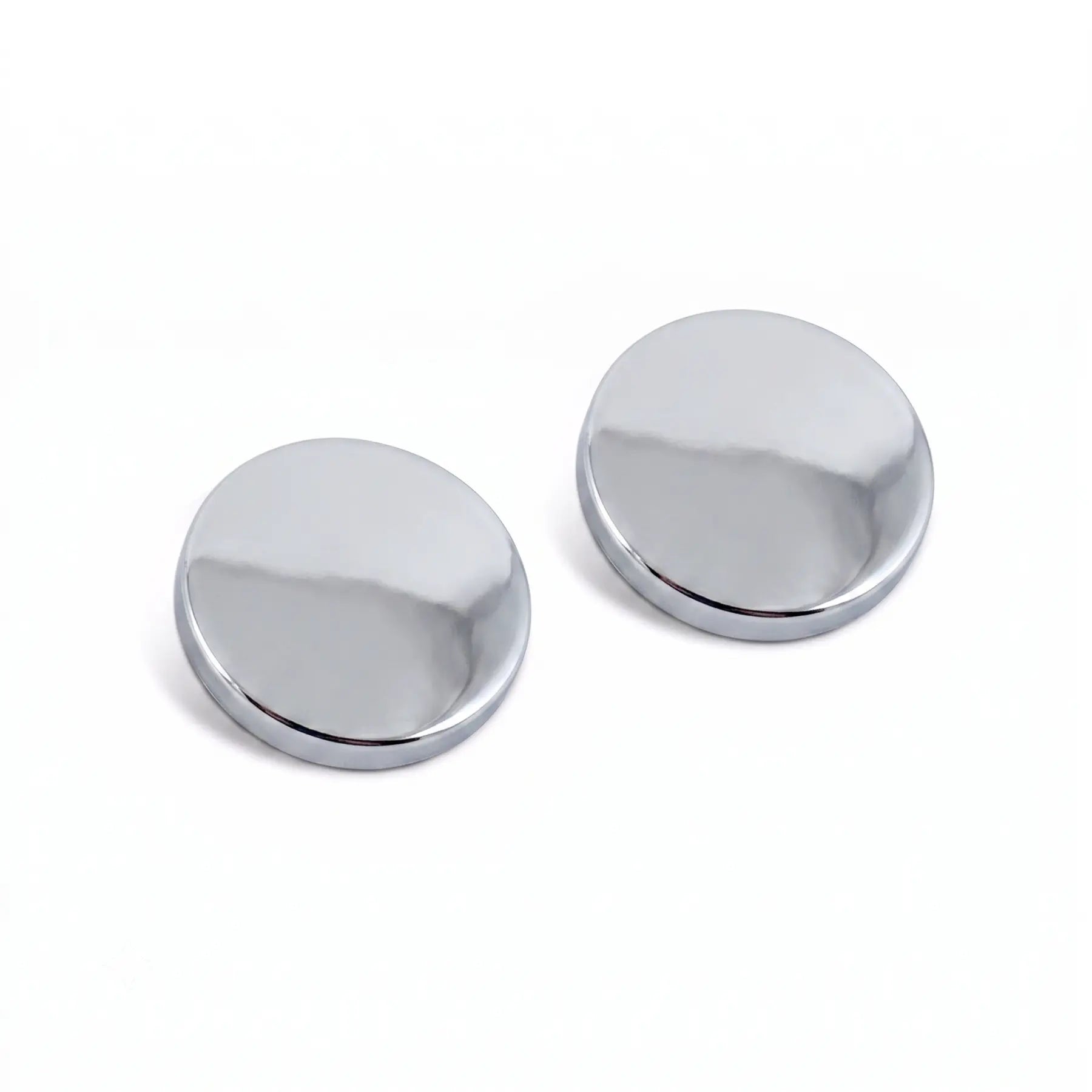 A close-up image showing a polished chrome screw cap being snapped onto a screw head, with a hand gently pressing down to secure the cap in place, creating a clean and polished look.