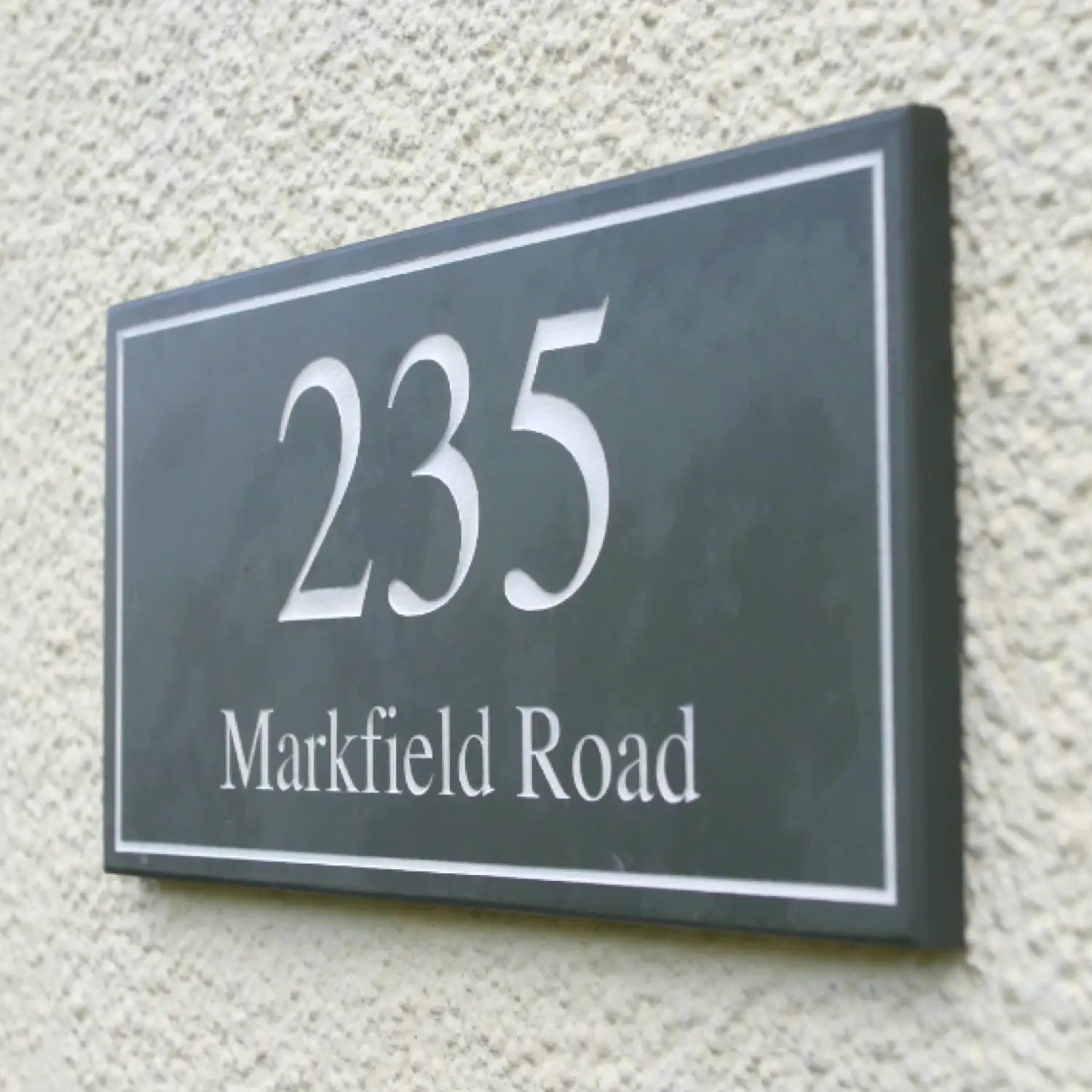 Slate house name and number signs with number '235' on top and 'Markfield Road' below