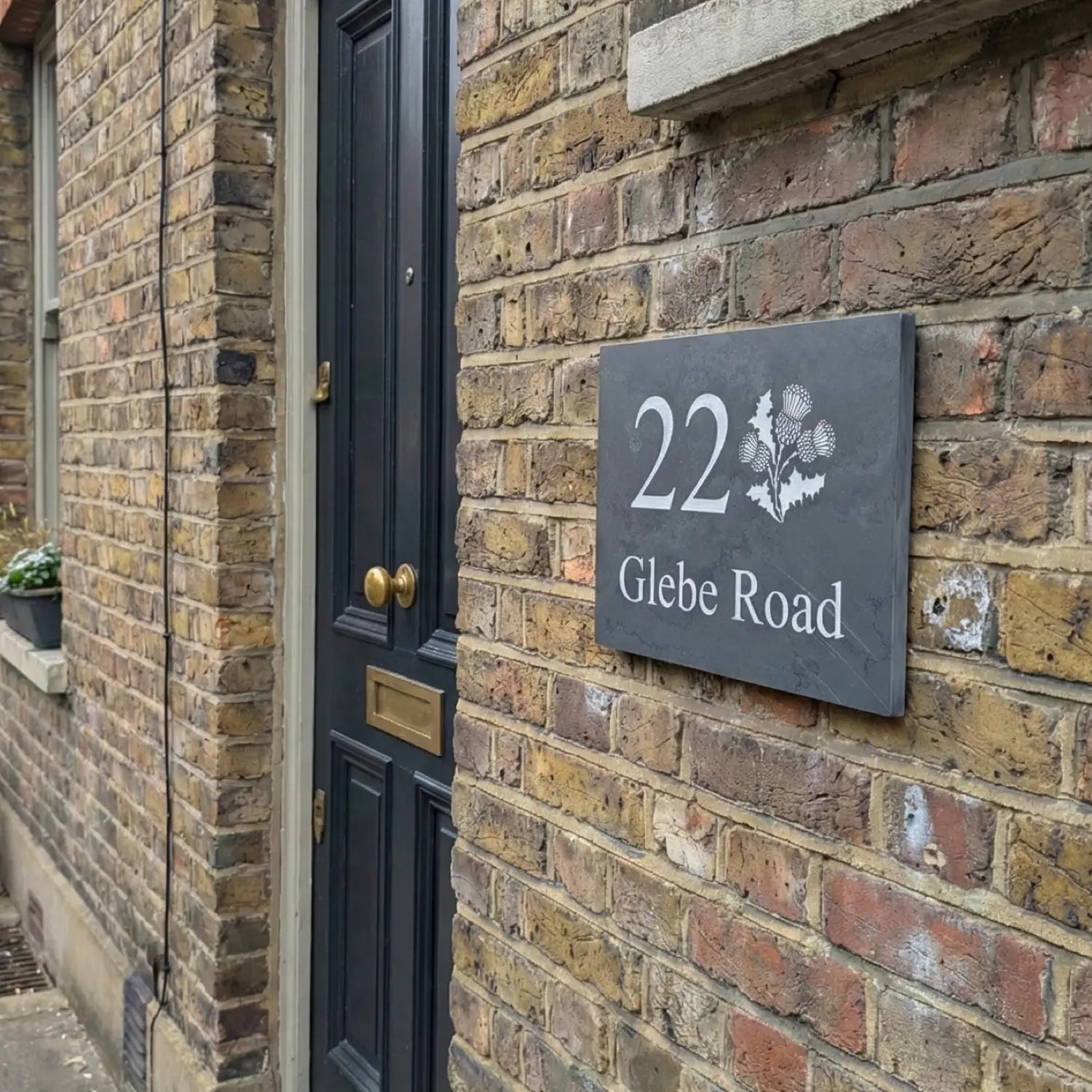 House number sign on a brick wall next to a door