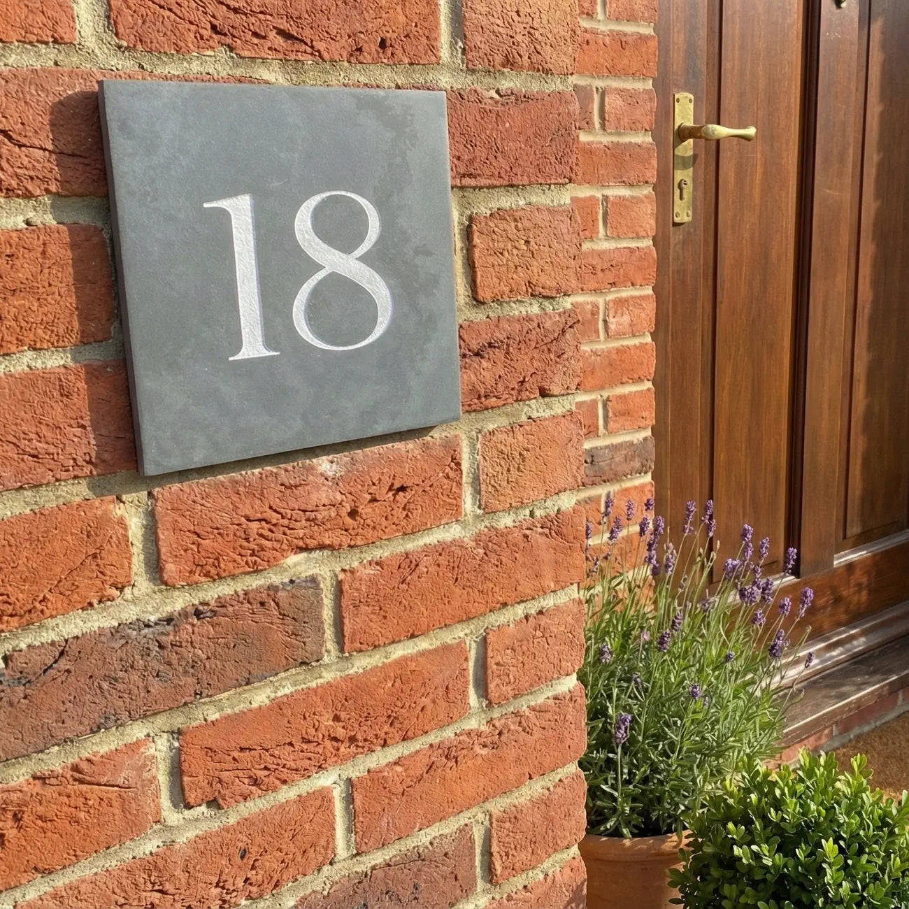 a side view of a grey slate house number sign