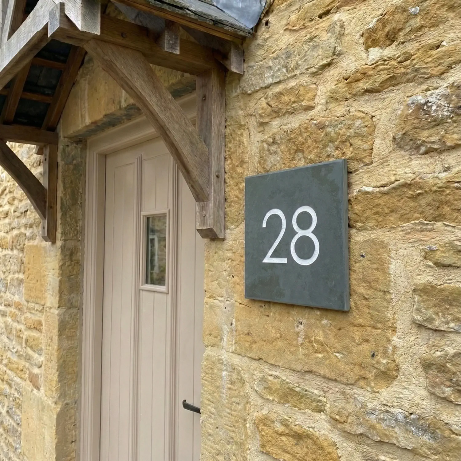 a side view of a grey slate house number sign