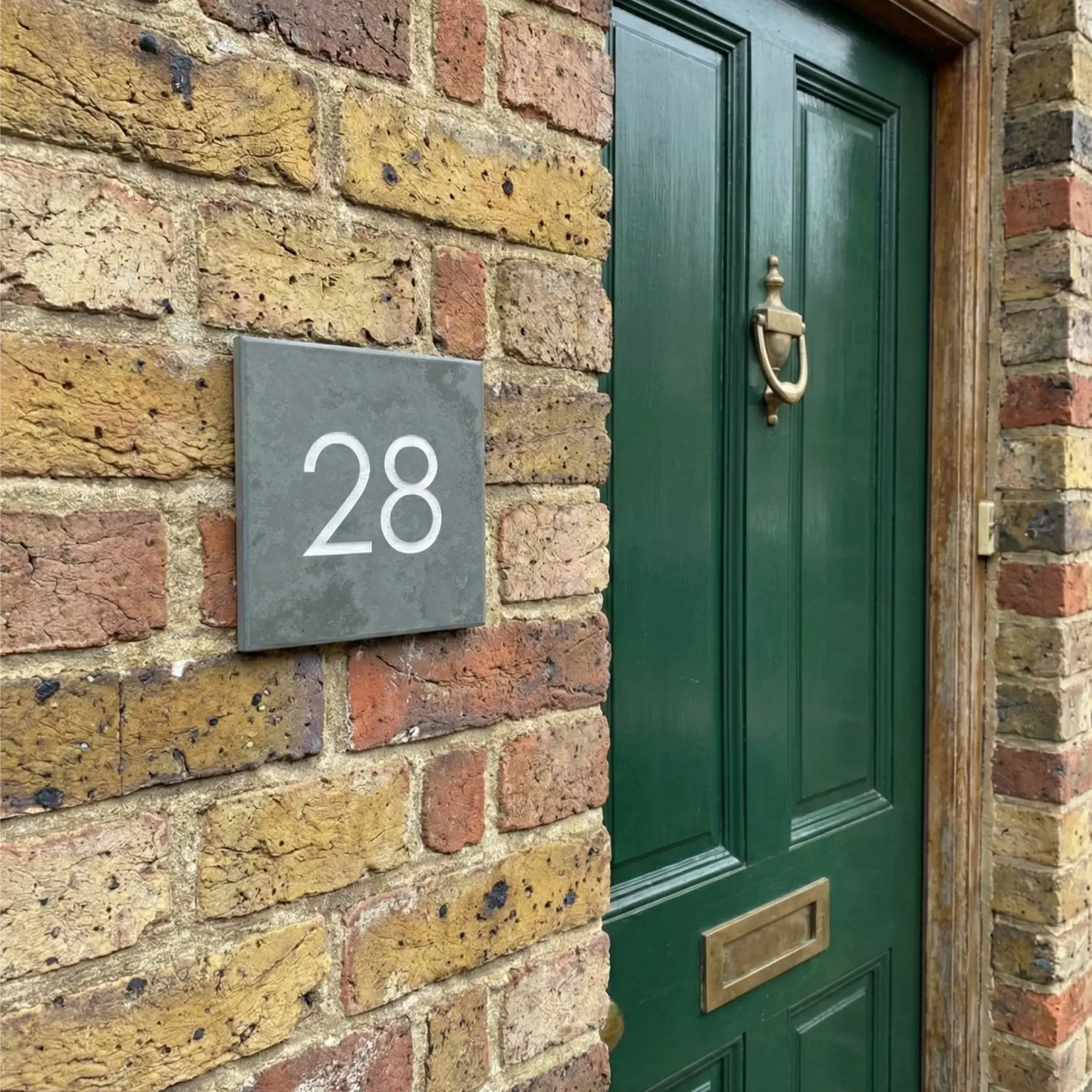 a side view of a grey slate house number sign