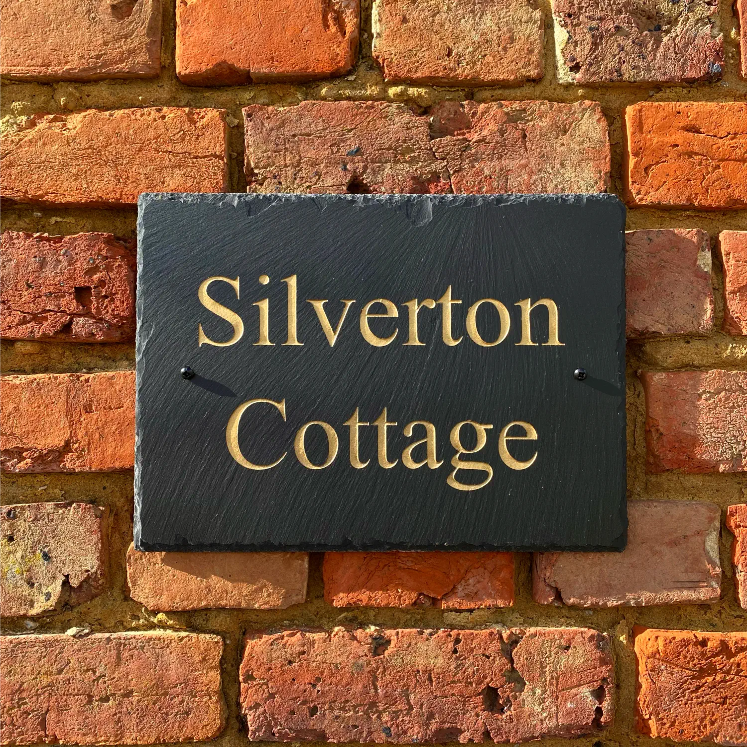 a chiselled welsh slate house sign with house name engraved in gold