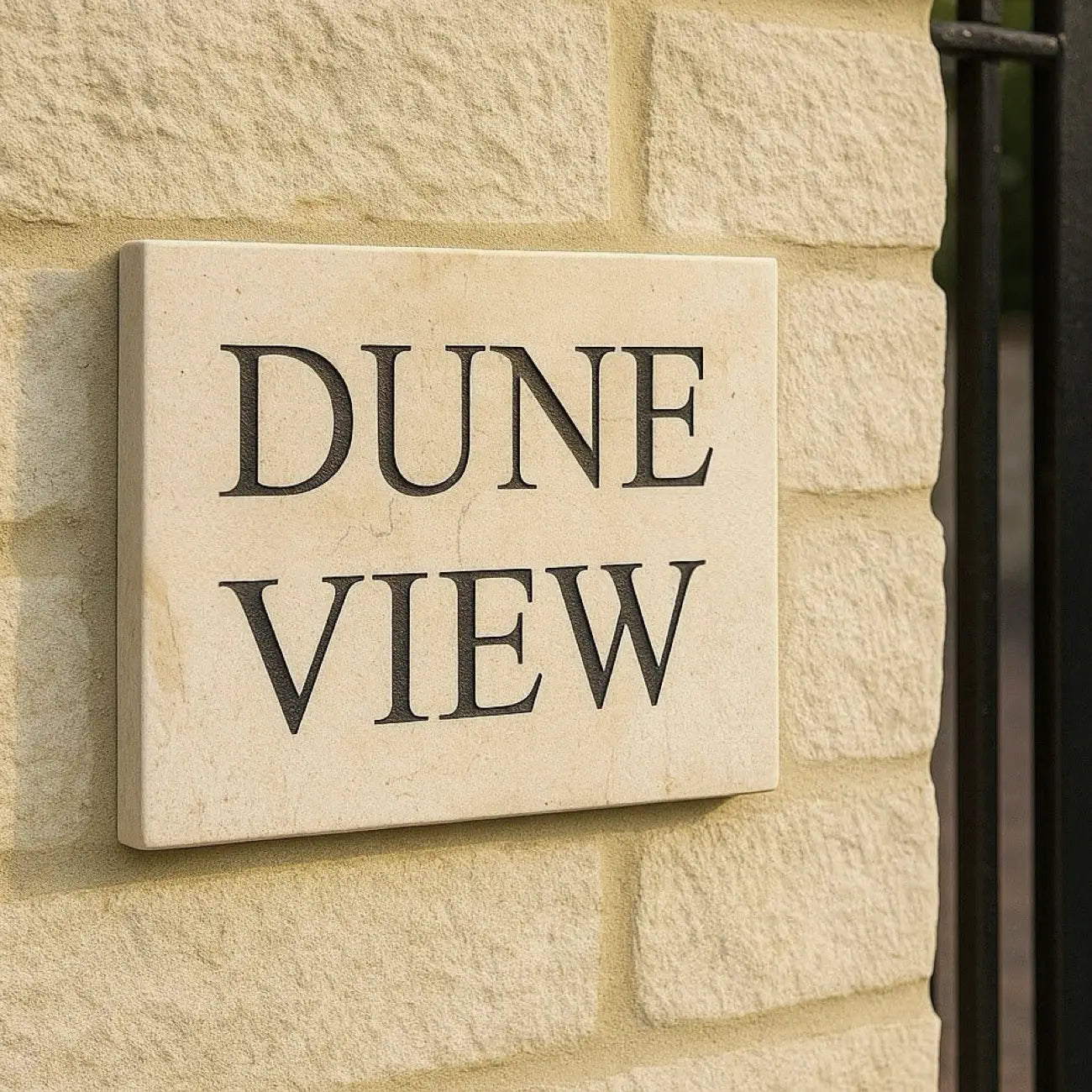 golden white limestone sign with 'DUNE VIEW' text on a stone wall