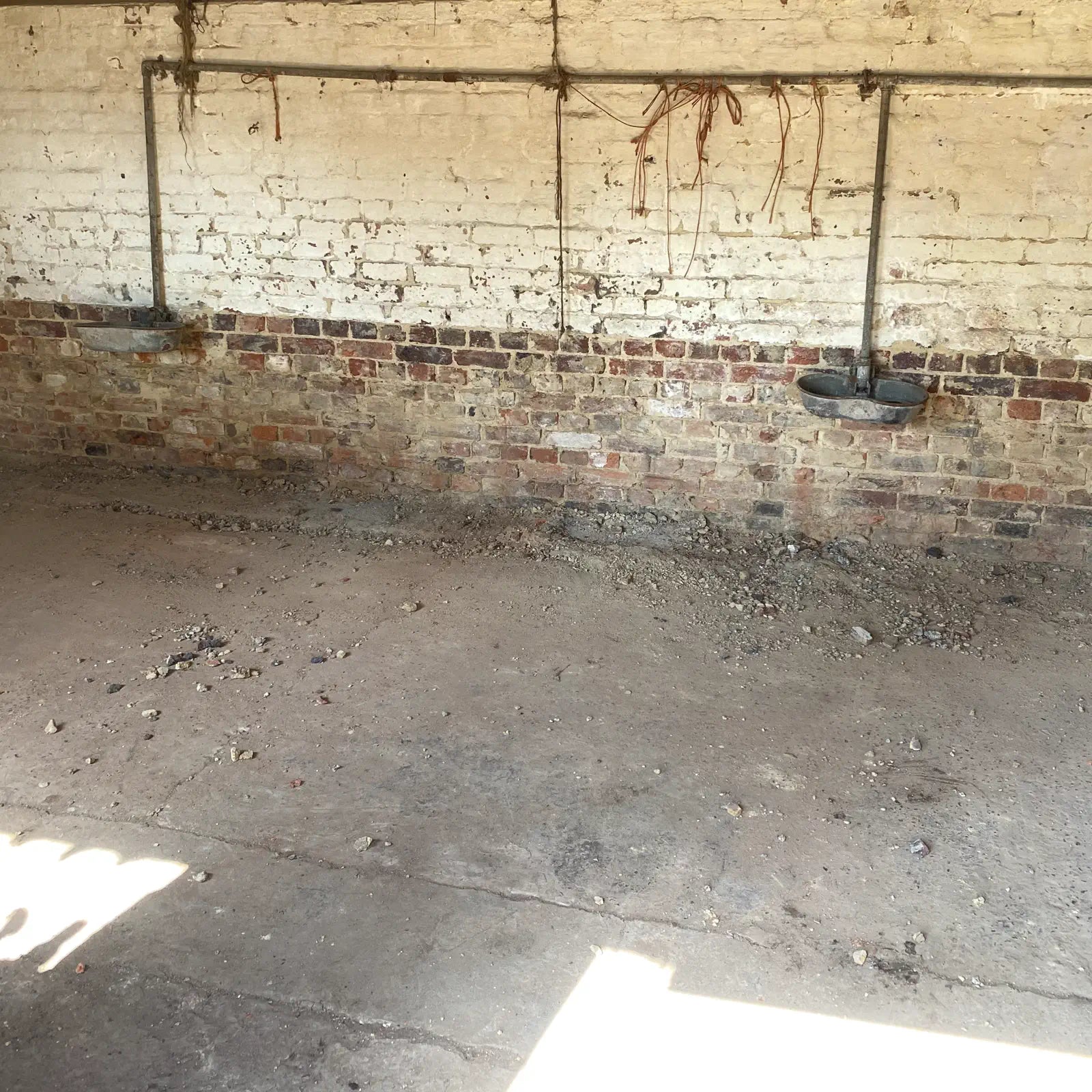 Dilapidated room with brick wall and concrete floor