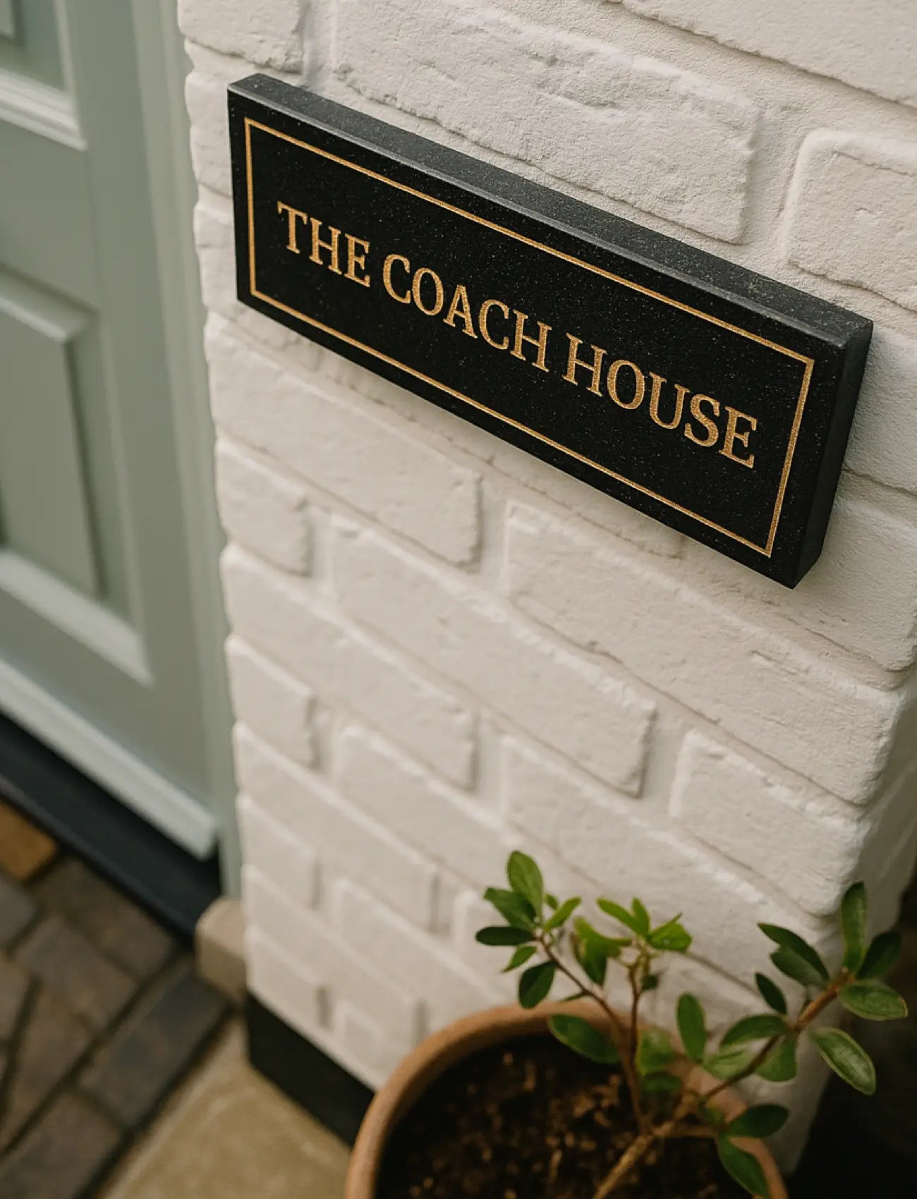 Stone pillar with 'Aykley Vale' granite sign in a snowy landscape
