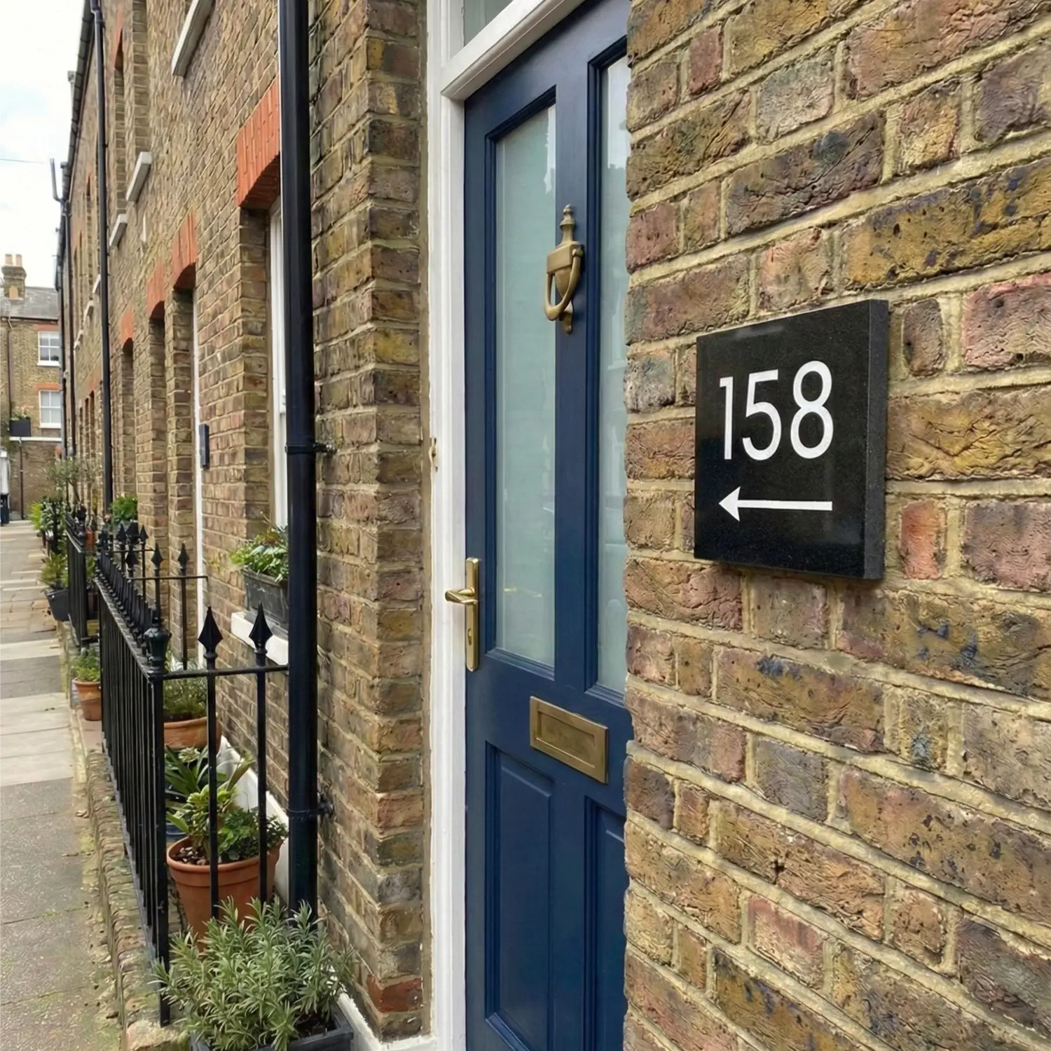 granite house number sign with 38 engraved in white with arrow pointing right