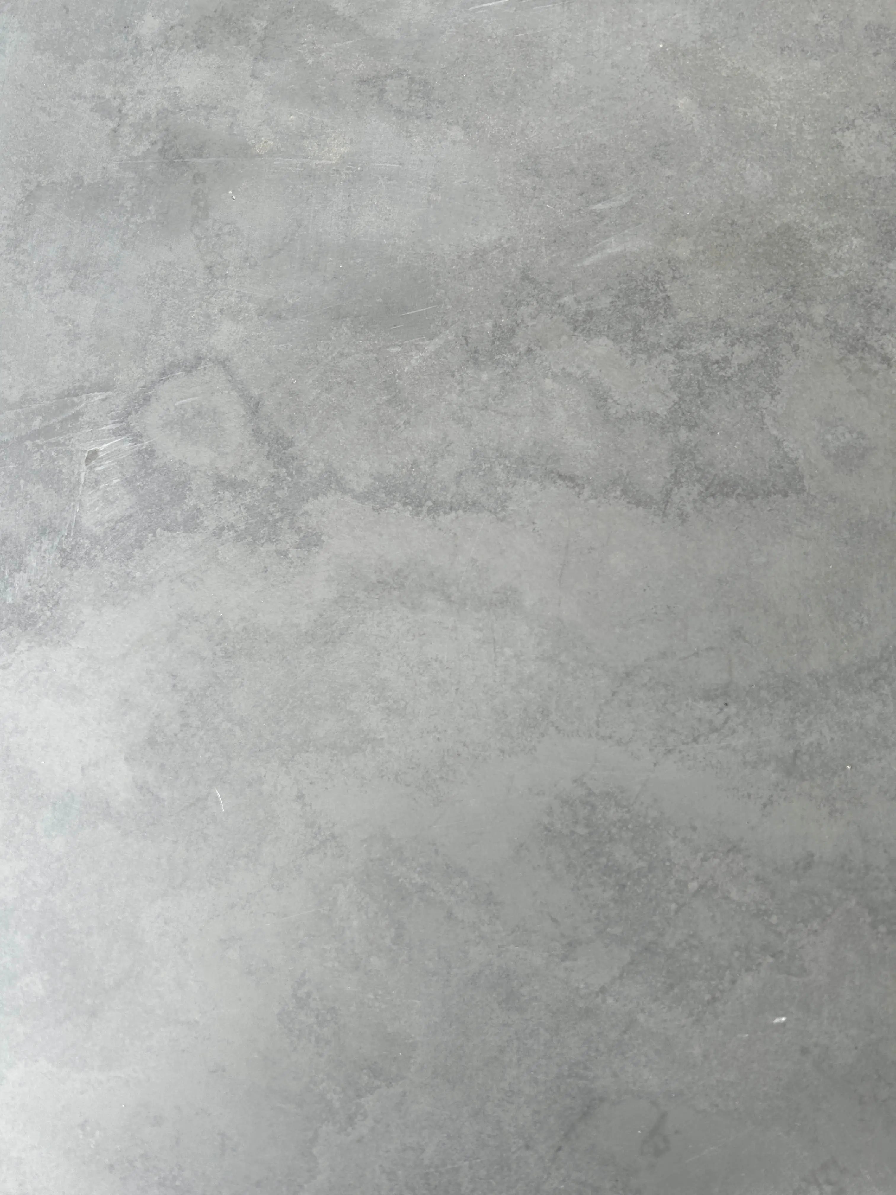 Close-up texture of natural grey slate showing fine grain, carbon depth, and iron sulphide mineral variations for signage.