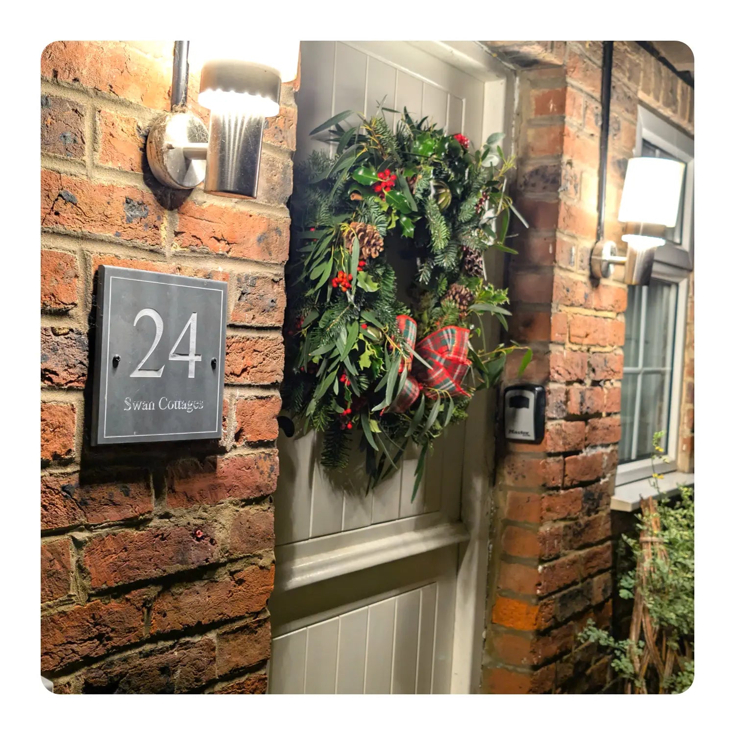 Decorative wreath on a door with house number 24 displayed.