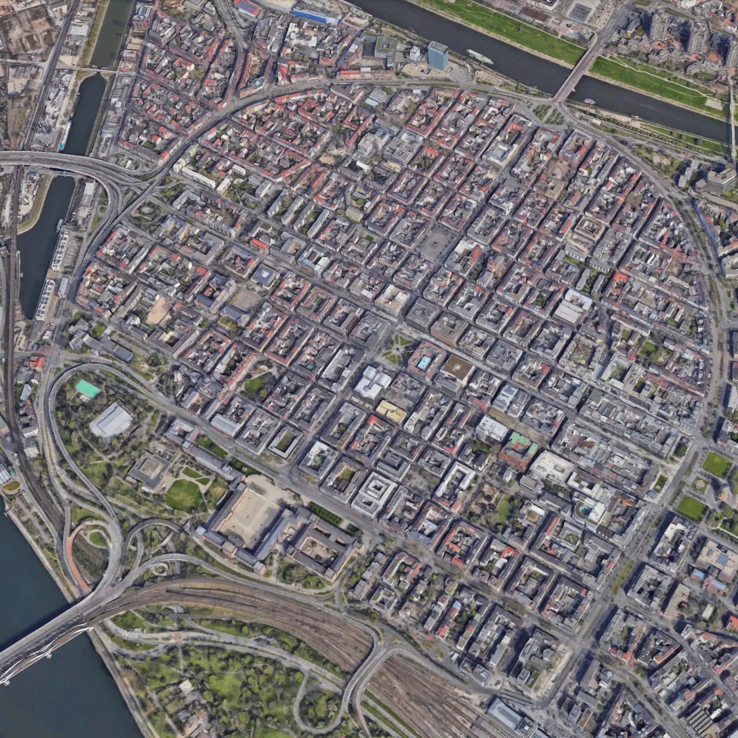 “Aerial view of Mannheim, Germany, showing its distinctive grid-like layout with symmetrical blocks and intersecting roads, bordered by rivers and green spaces.”