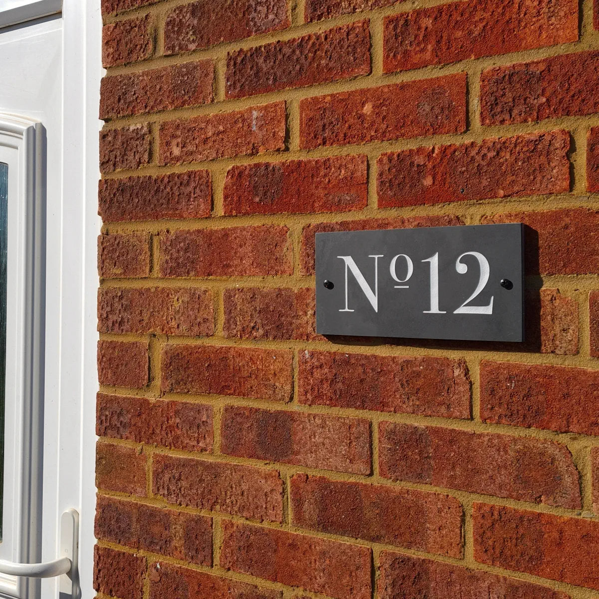 House number 'No. 12' on a brick wall
