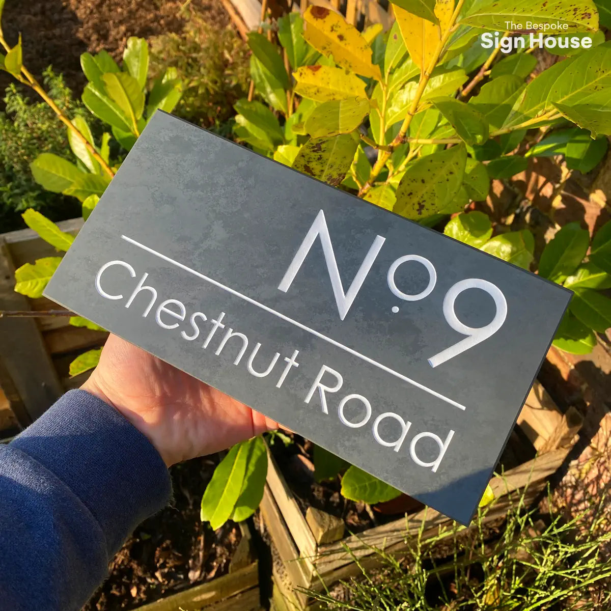grey slate house sign with the number 9 and chestnut road engraved into the surface and then painted white