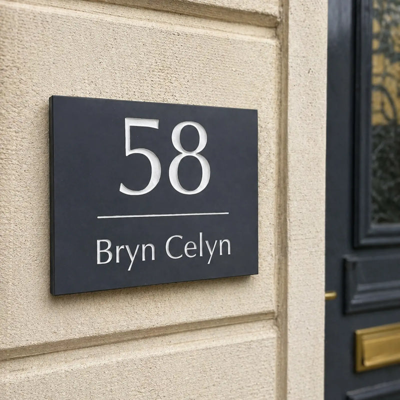 House number sign '58 Bryn Celyn' on a brick wall next to a door.