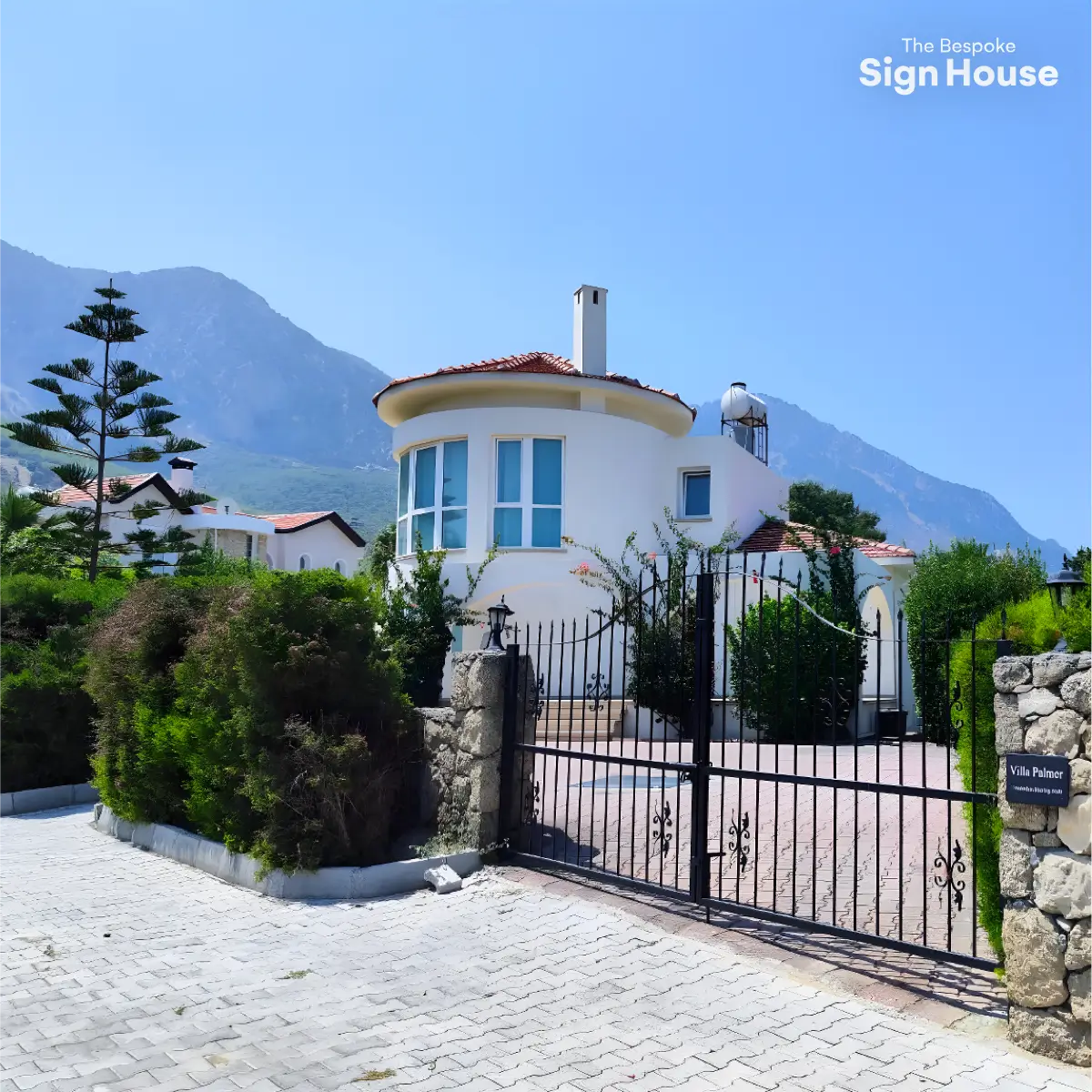a black slate welsh house sign with a what3words address engraved onto it in front of a white cypriot villa