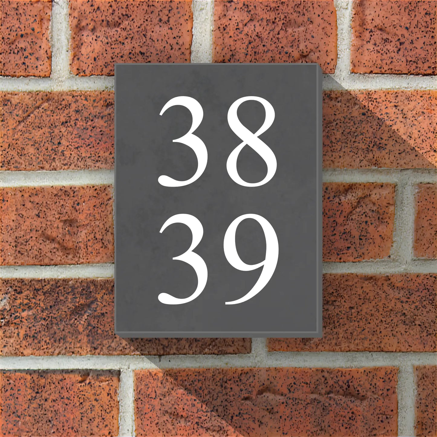 a slate door number sign two two numbers 38 and 39 on a red brick wall