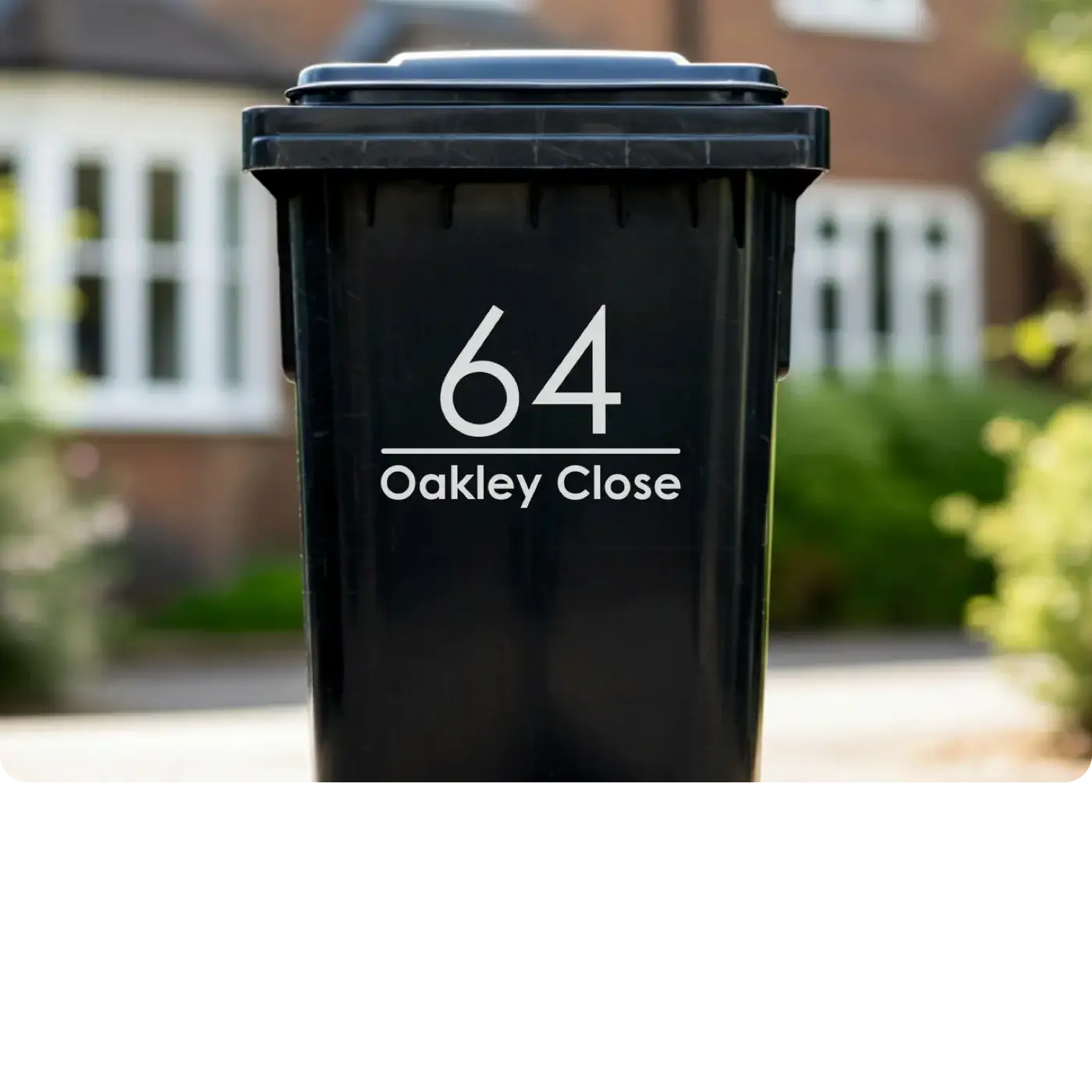 Black bin with '64 Oakley Close' printed on it, set against a blurred background of a house and garden.