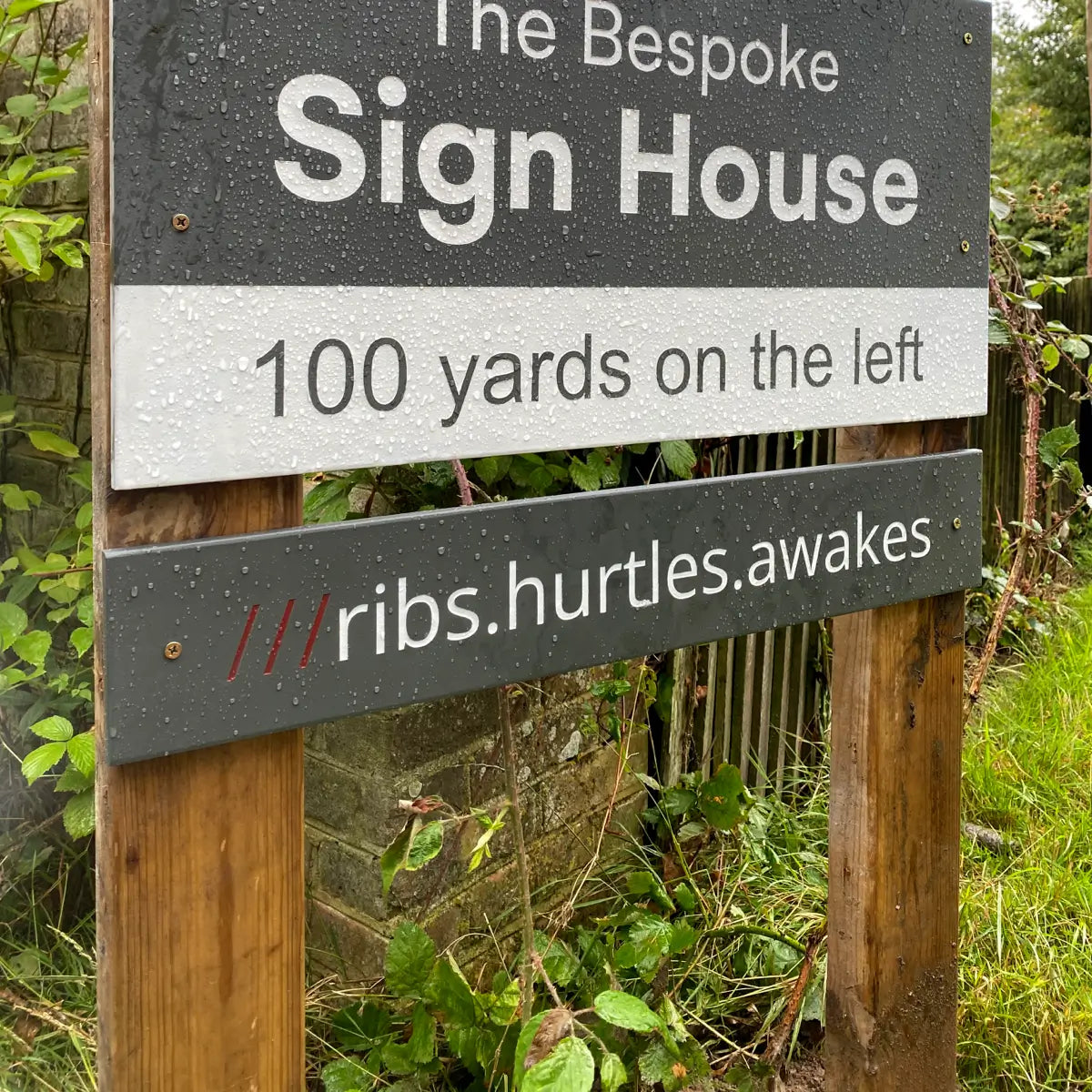 a what3words plaque on a business directions road sign