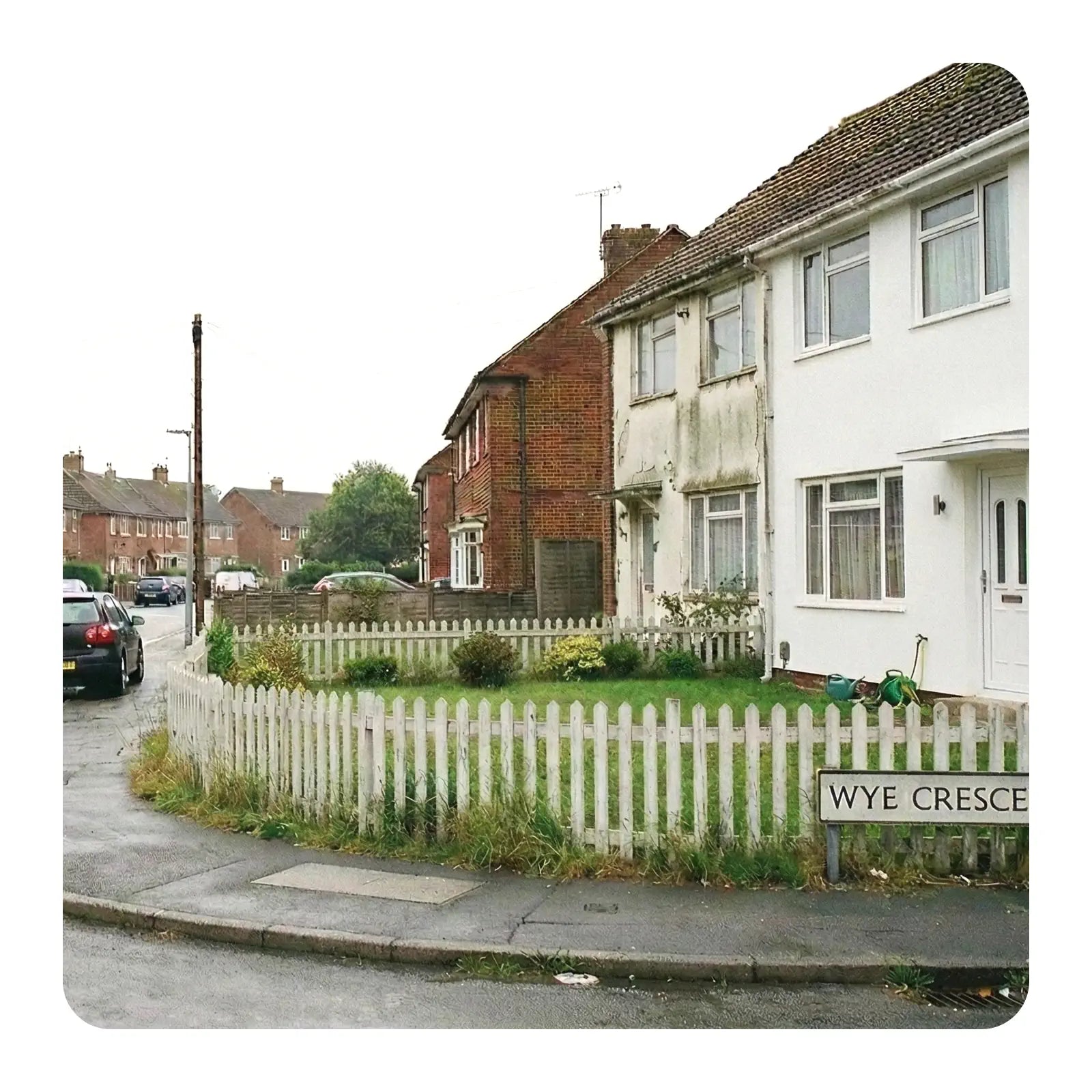  residential street with houses and a white picket fence