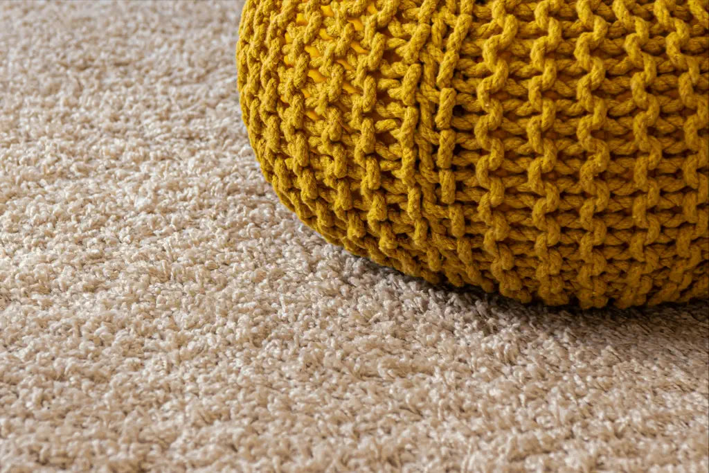 a yellow foot stool on a brand new beige carpet
