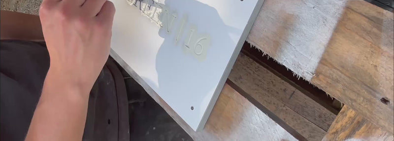 video of our signmaker handpainting a slate sign using a paintbrush. the paint colour is little green olive