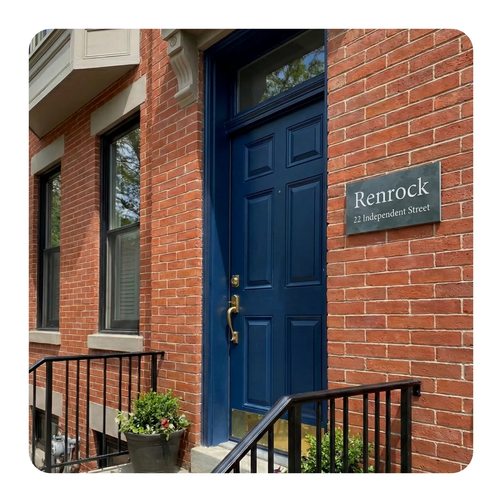 Brick building with a blue door and 'Renrock' sign