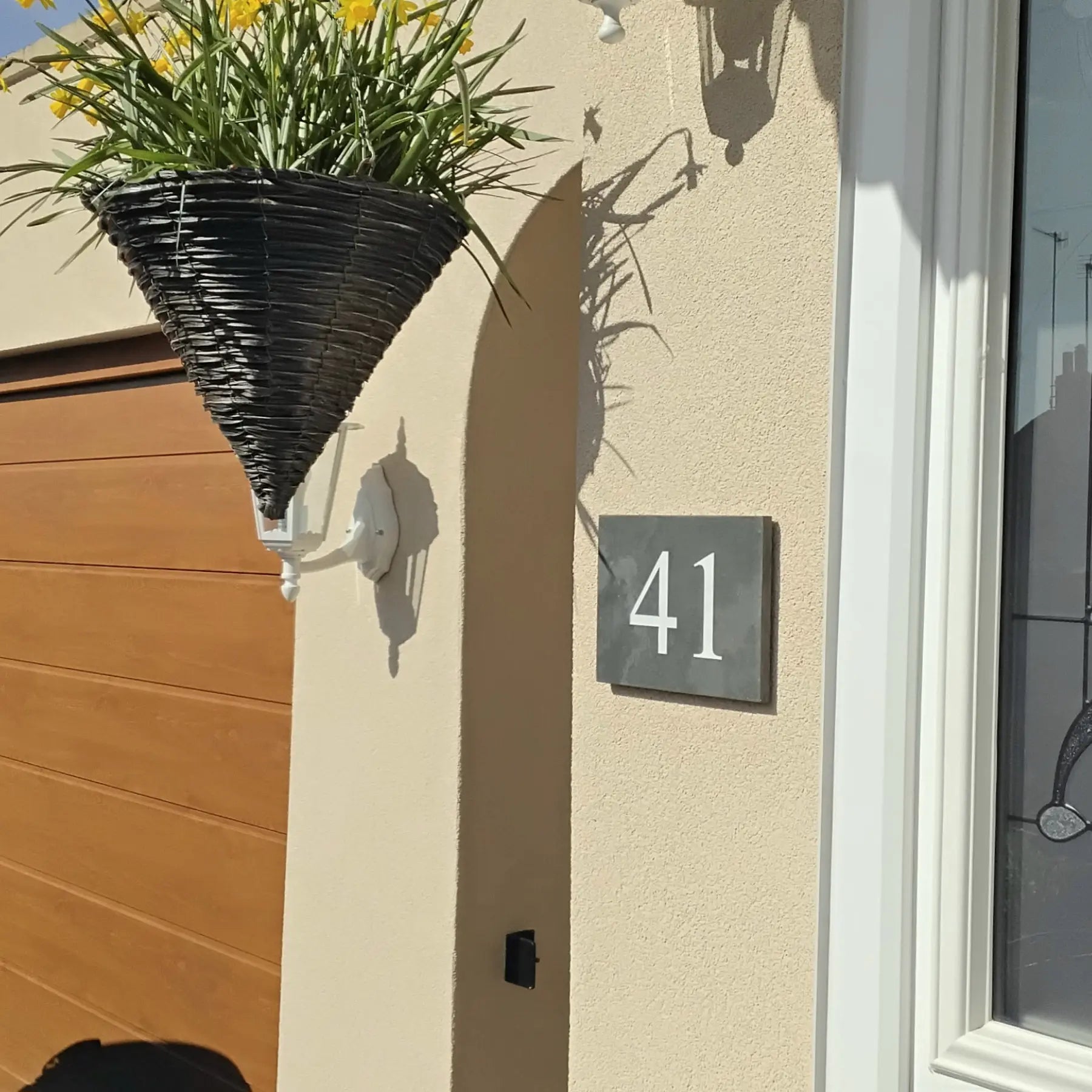 House exterior with a flower pot and house number 41 on a beige wall.