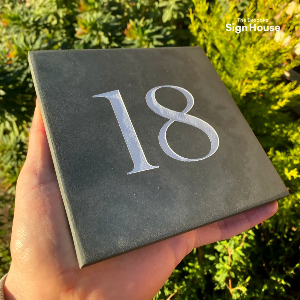 a side view of a grey slate house number sign