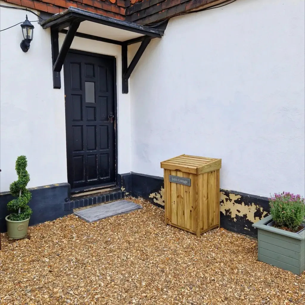 house entrance area with black front door and a small wooden postbox to the right