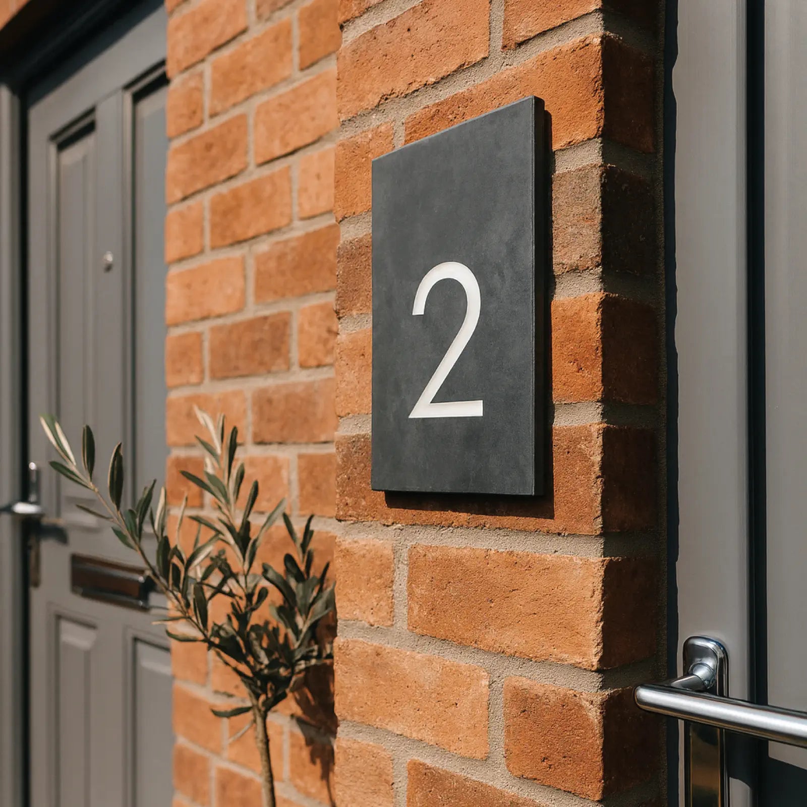 House number '2' on a brick wall next to a door