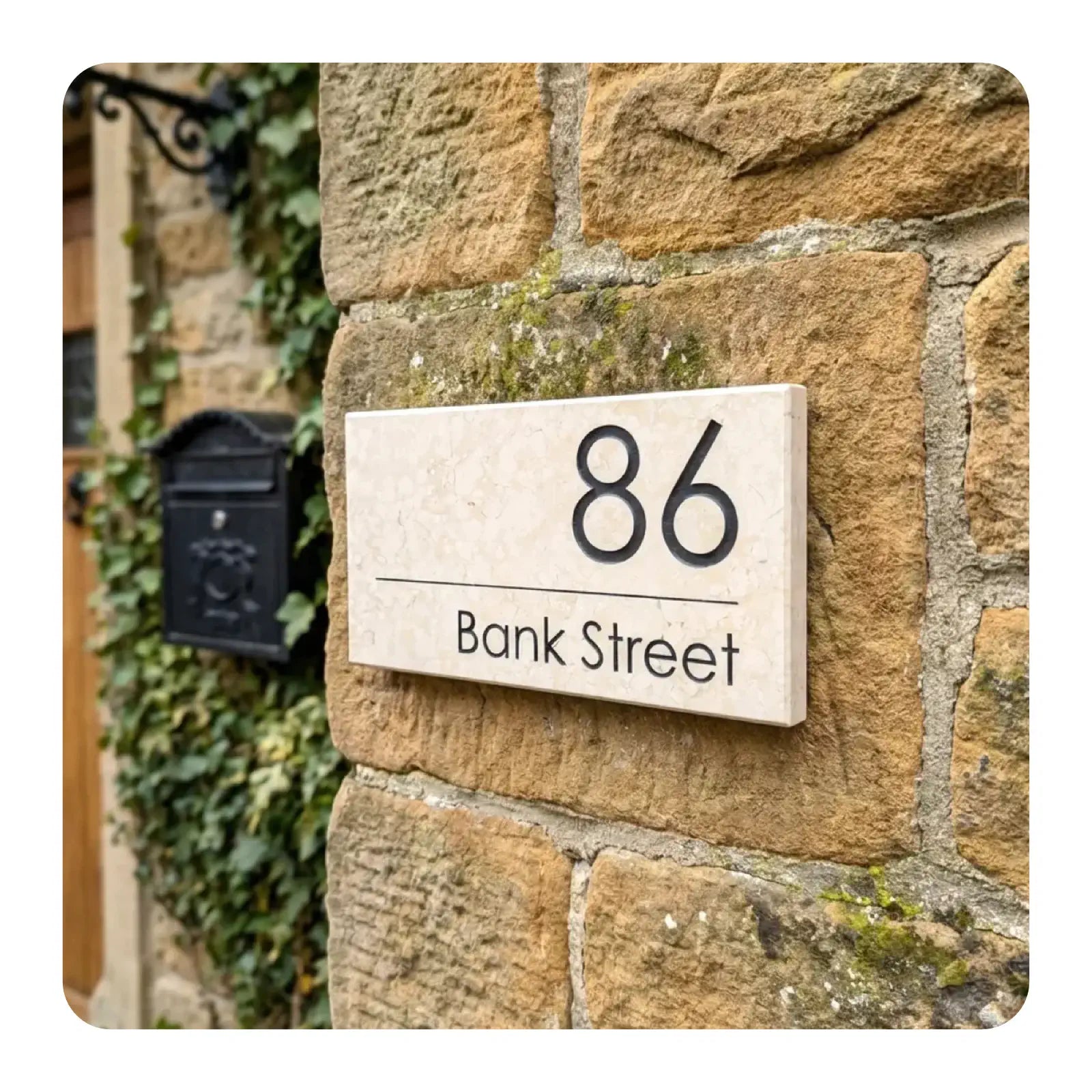 House number 86 Bank Street on a stone wall with a mailbox.