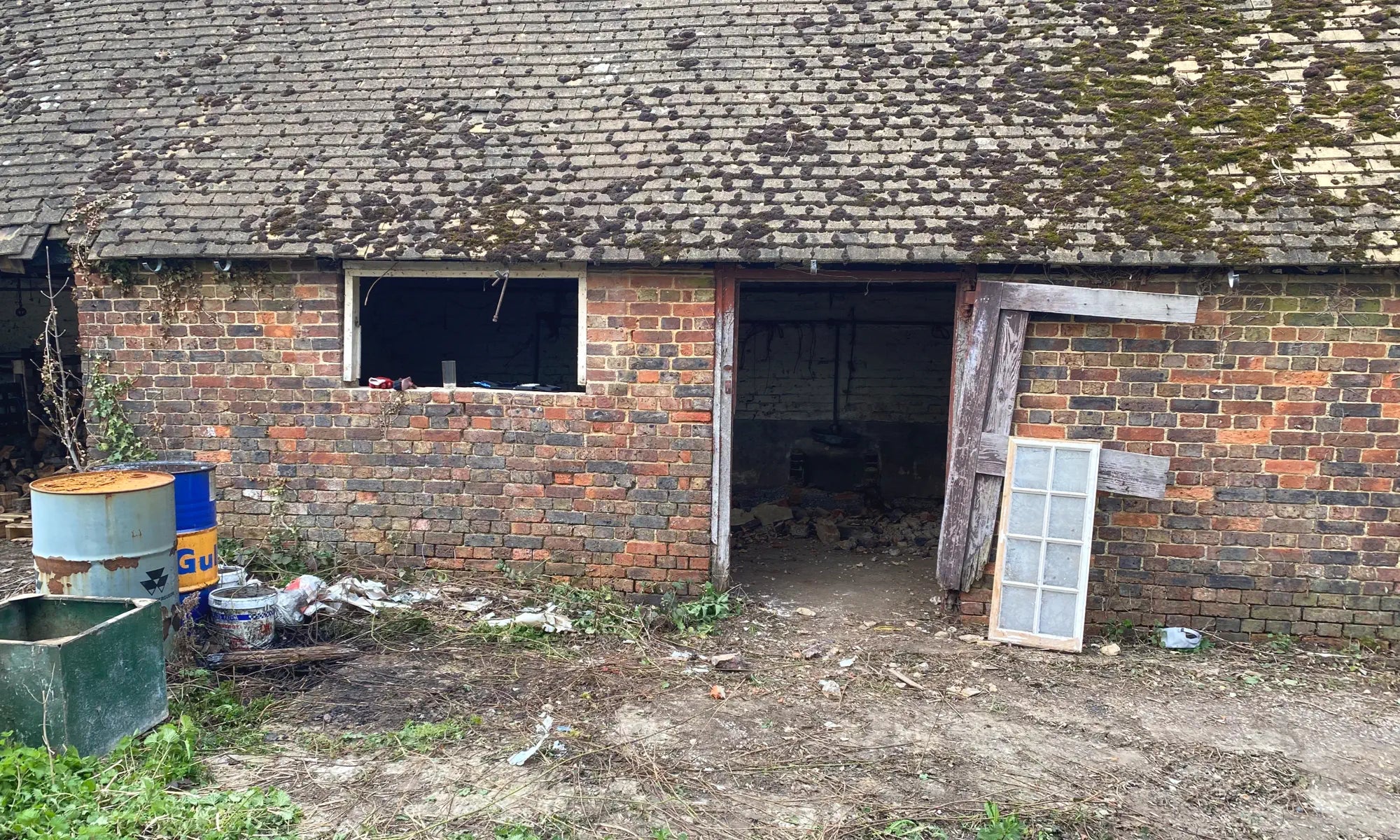 Abandoned barn with broken windows and a dirt floor