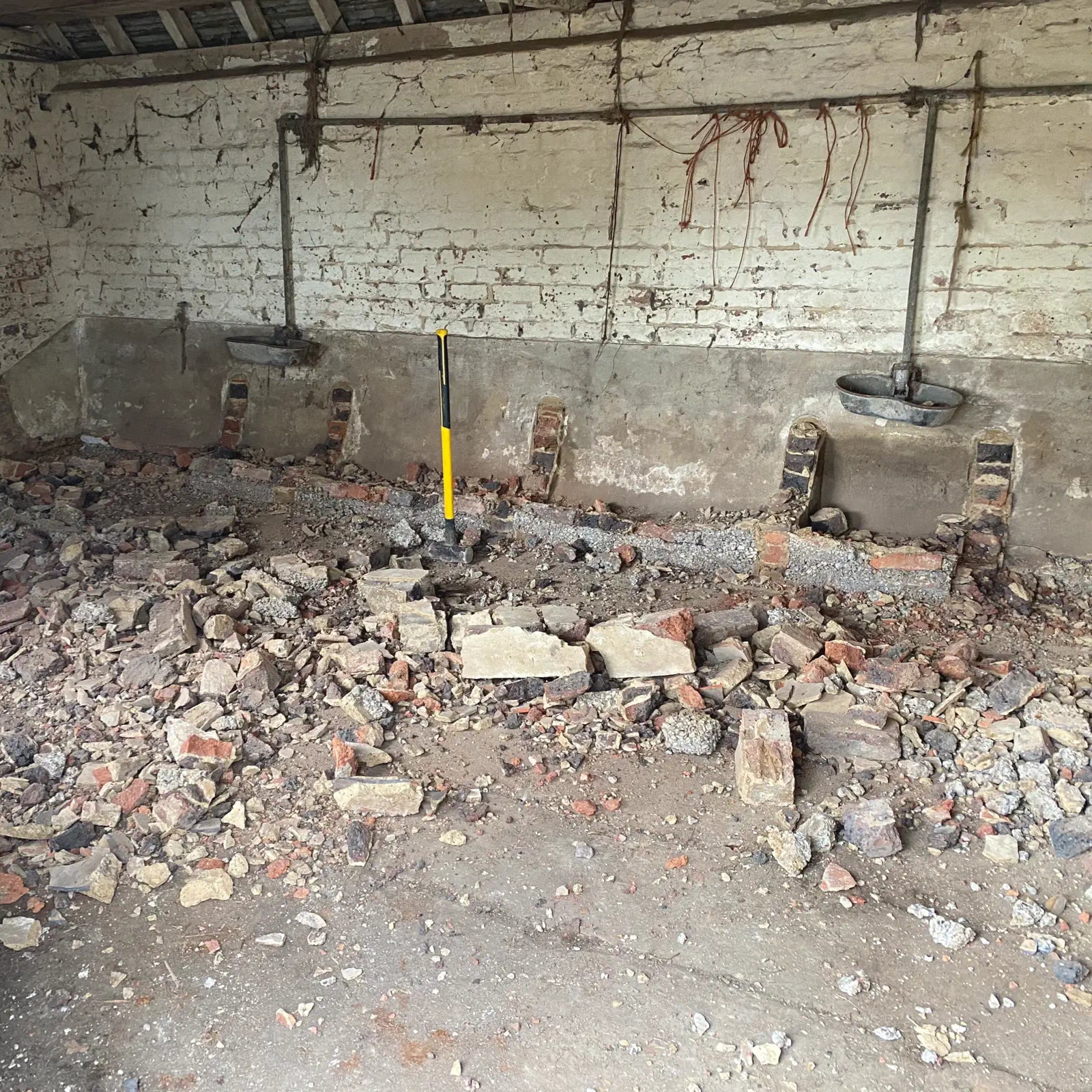 Ruined interior of a building with debris and broken bricks on the floor.