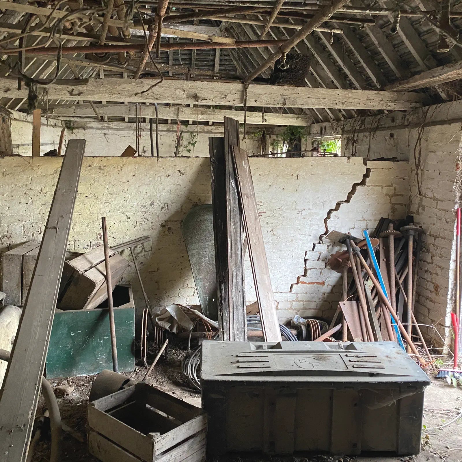 Interior of an old building with wooden beams and scattered debris