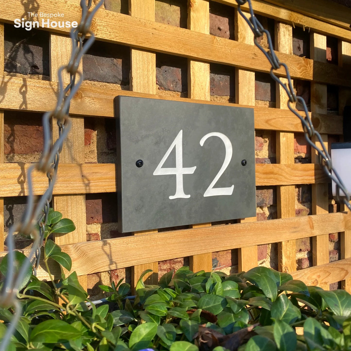 slate number sign with engraved 42 in white paint on front of house.