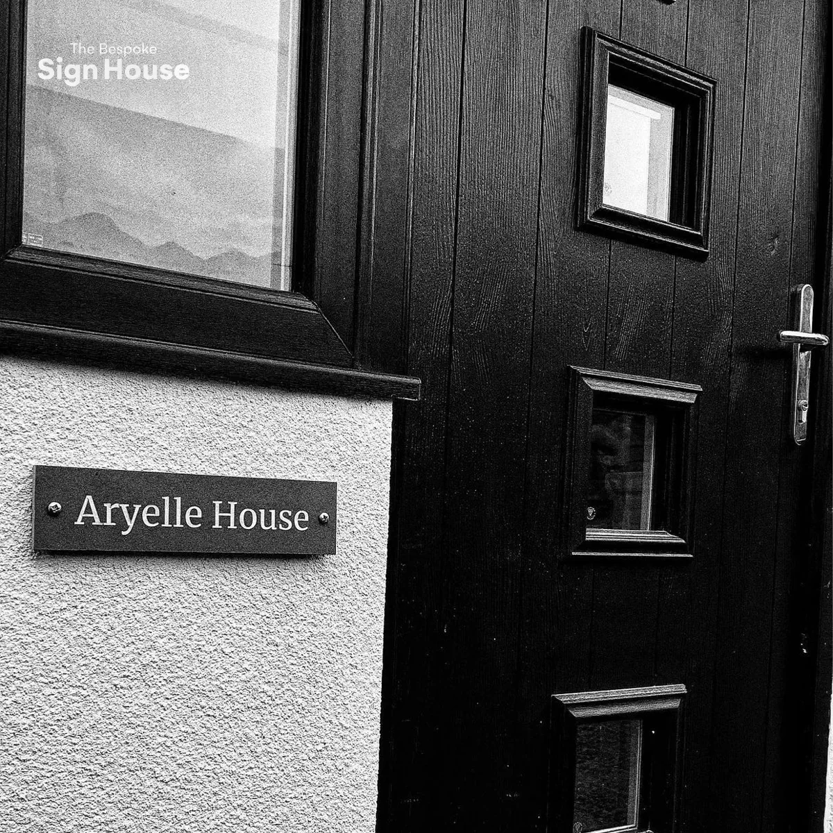 black slate sign next to black house front door